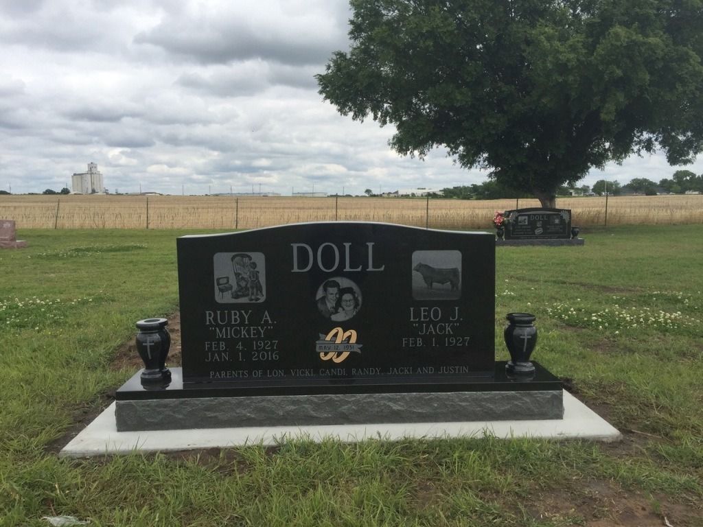 A black gravestone with the name doll on it