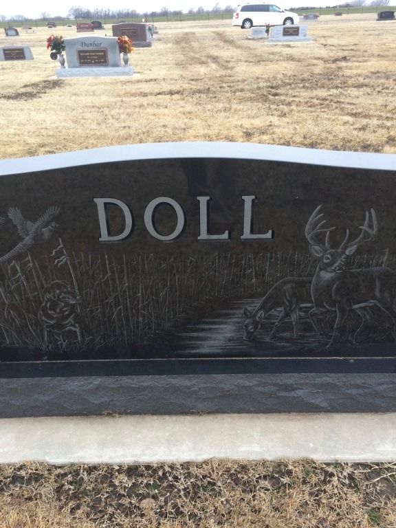 A black gravestone with the name doll on it