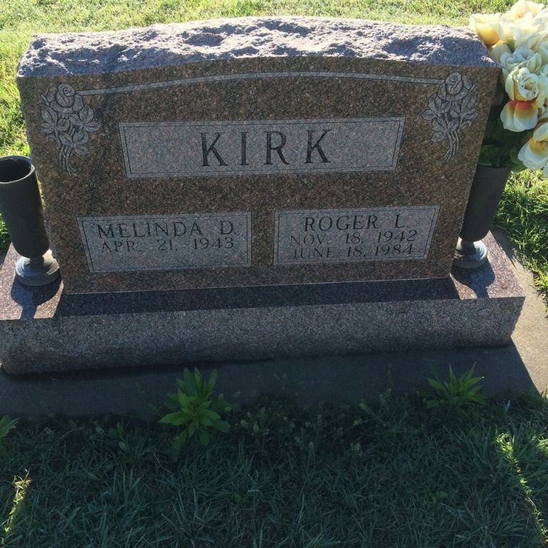 A gravestone for melinda and roger kirk in a cemetery