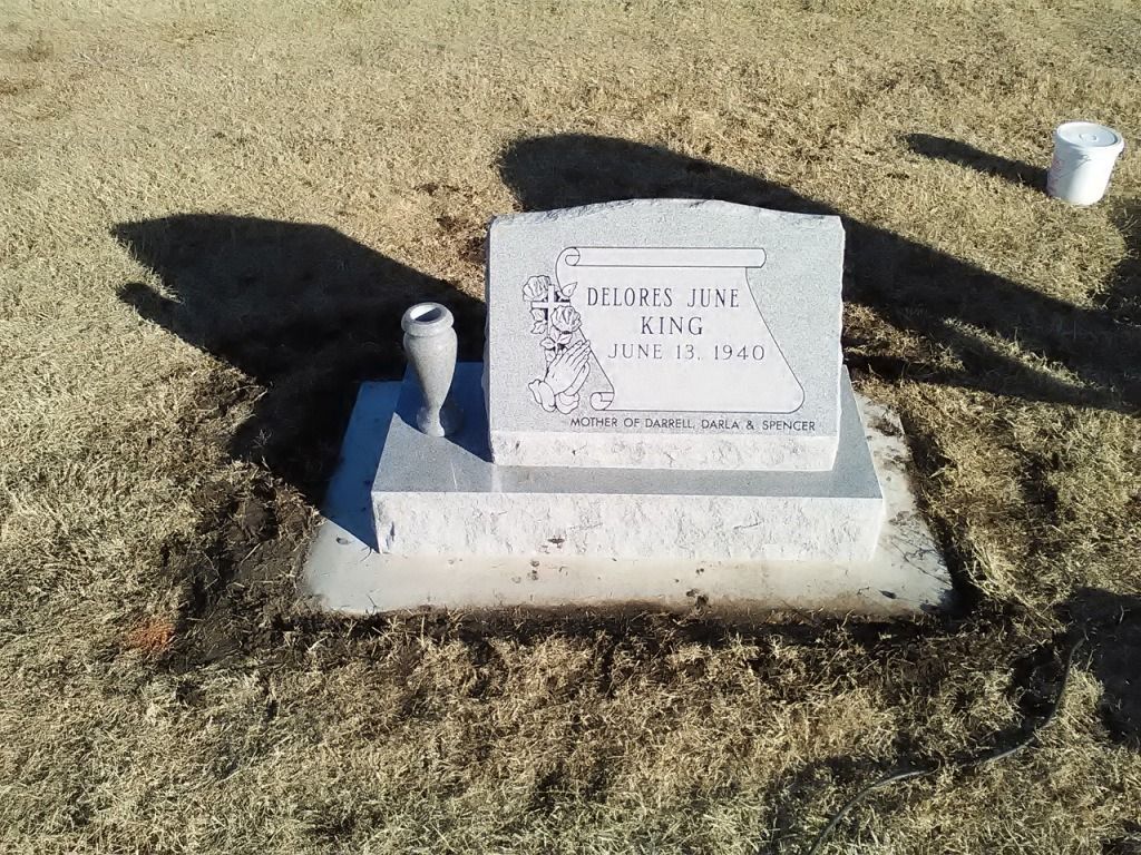 A grave in a cemetery with a vase on top of it