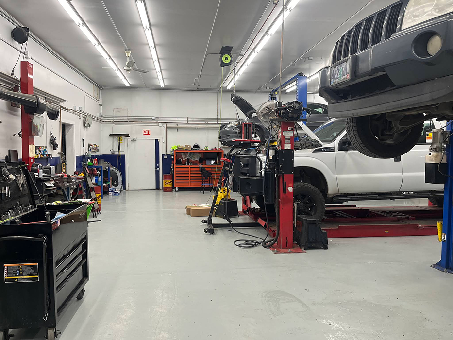 Auto repair shop interior: vehicle on lift, tools, and toolboxes. | King's Auto LLC