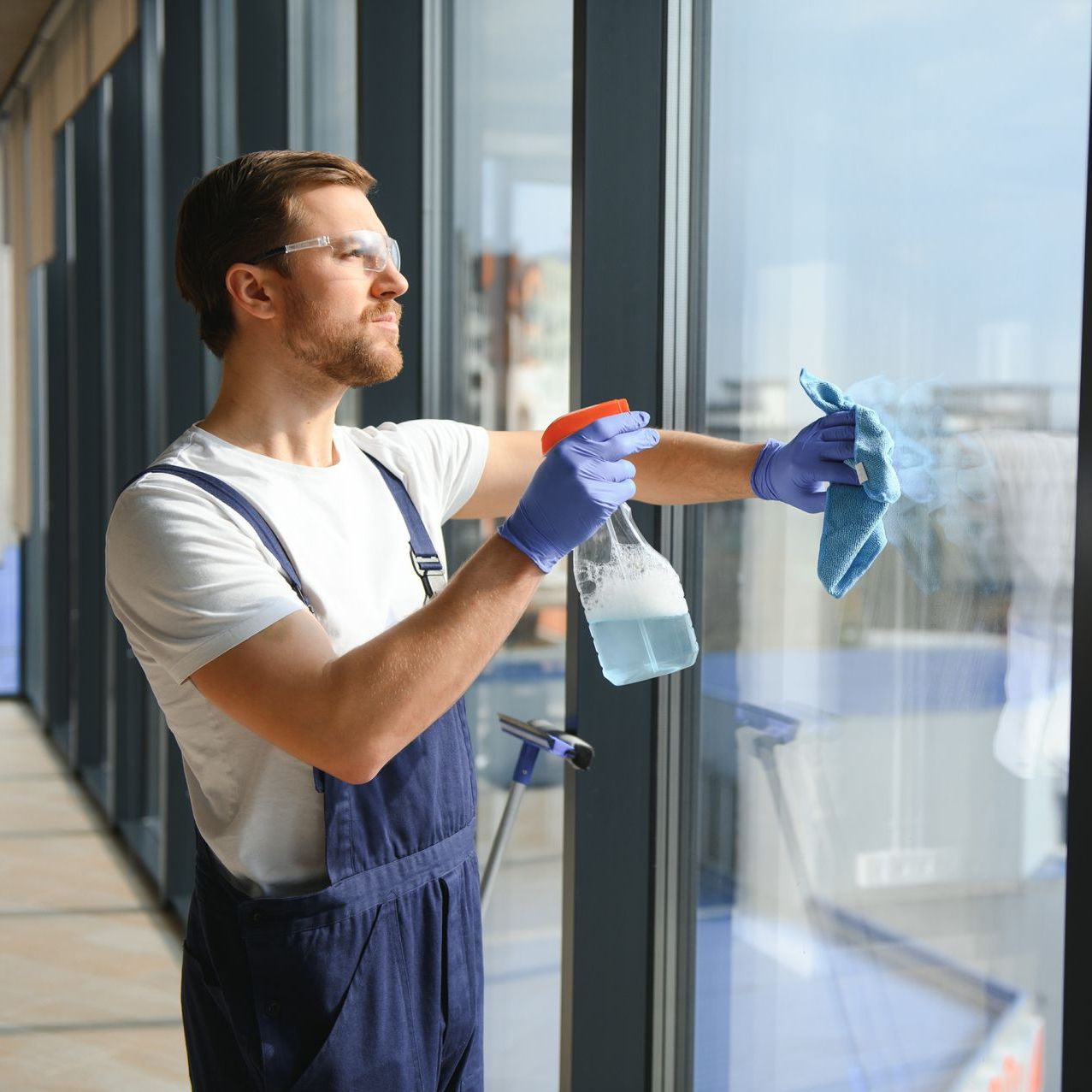 man cleaning office window 