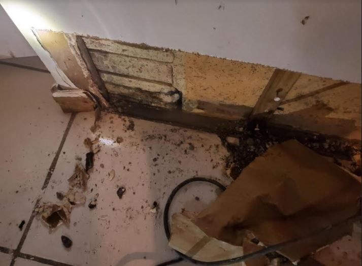 A person is looking at a hole in a wall