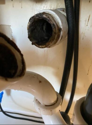 A close up of a sink with a dirty pipe
