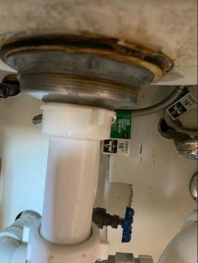 A sink with a white pipe underneath it