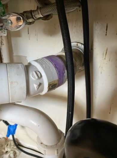 A close up of a pipe under a sink in a bathroom