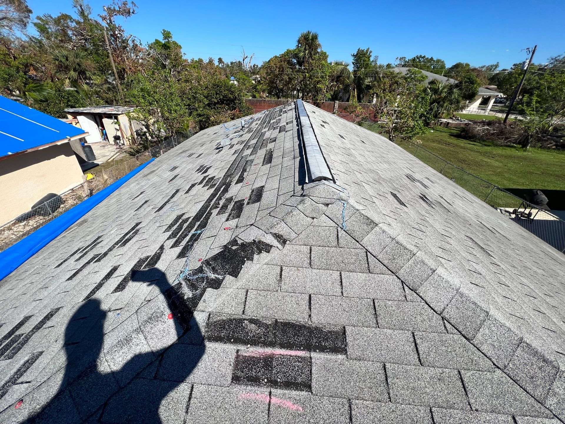 A shadow of a person is cast on the roof of a house.