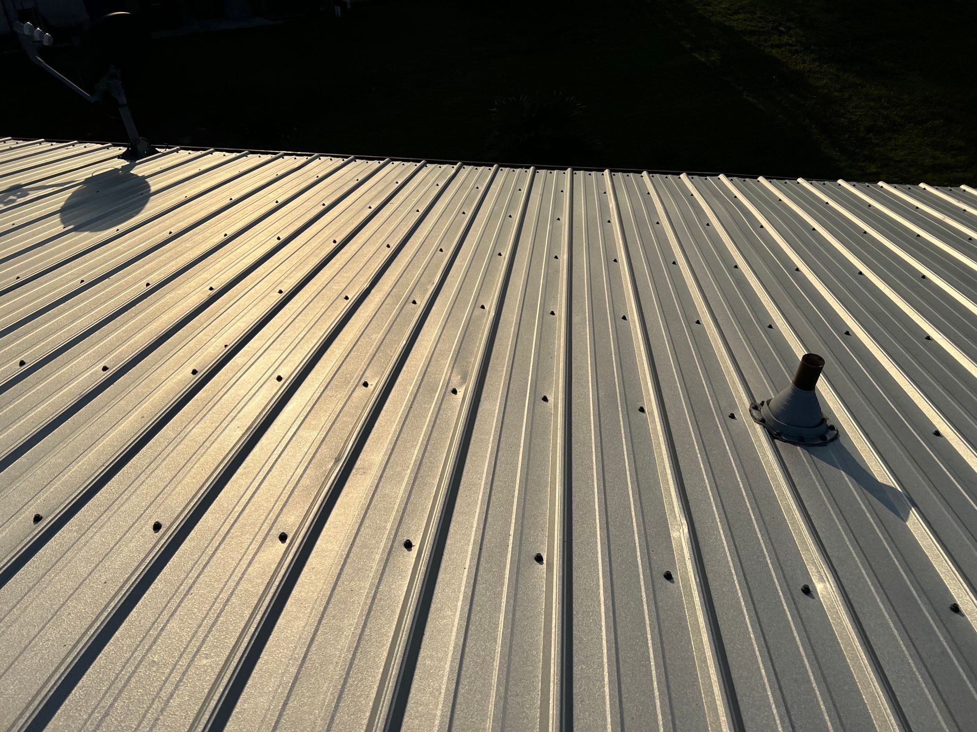 A metal roof with a chimney on top of it