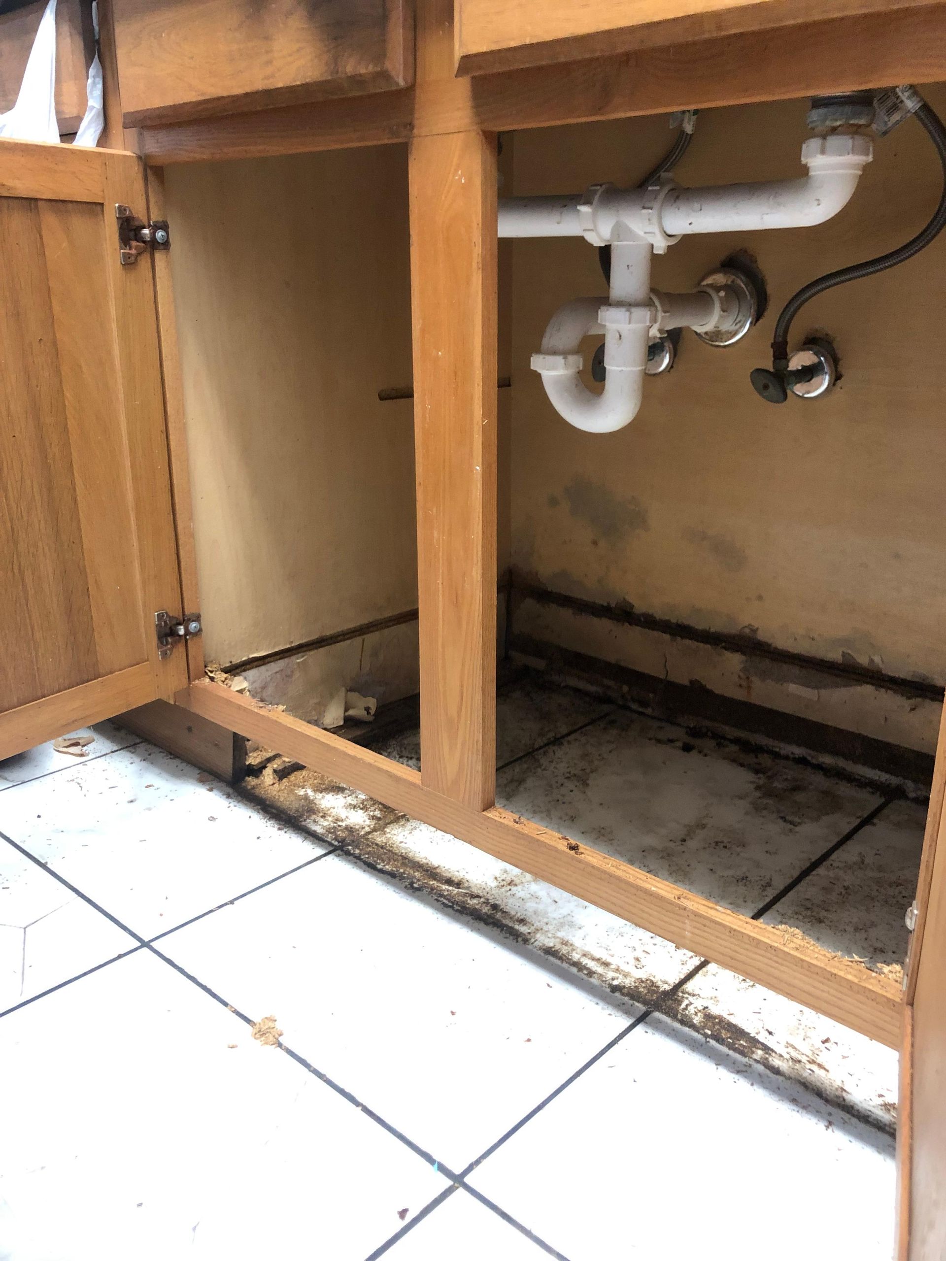 A kitchen sink with a white pipe underneath it