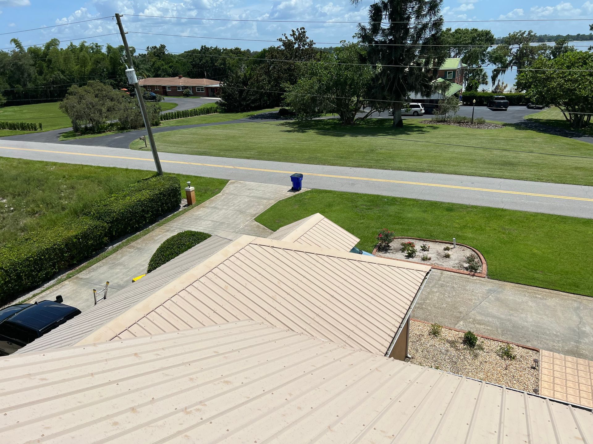 An aerial view of a house with a roof and a road in the background.