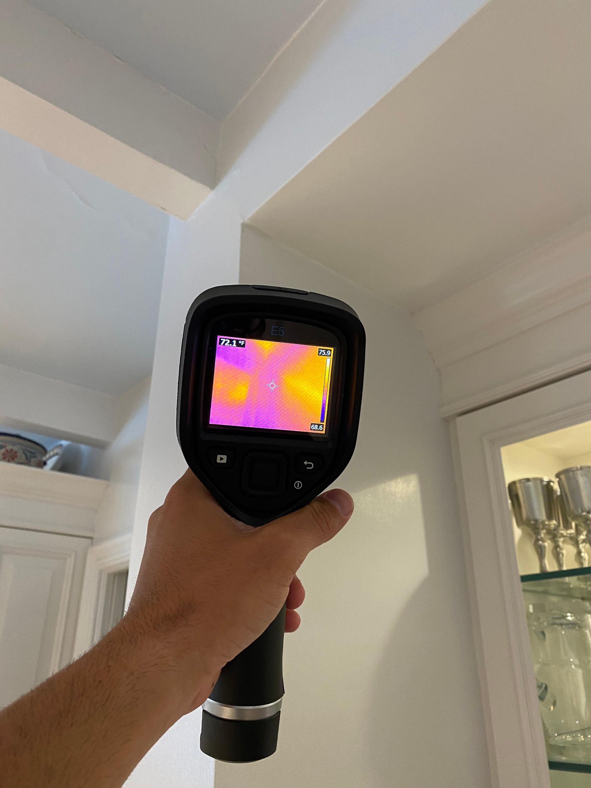 A person is holding a thermal camera in their hand.