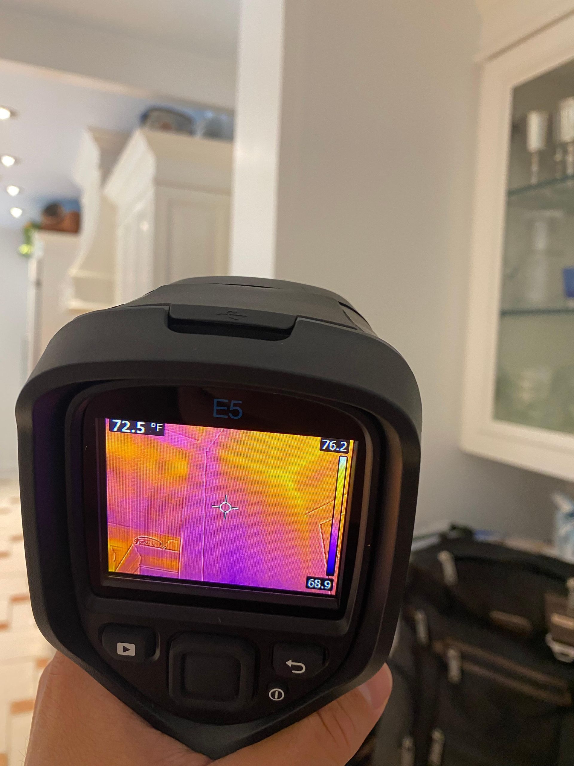 A person is holding a thermal camera in their hand.