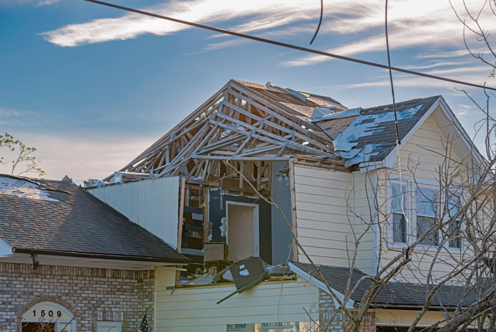 A house with a roof that has been damaged by a tornado.
