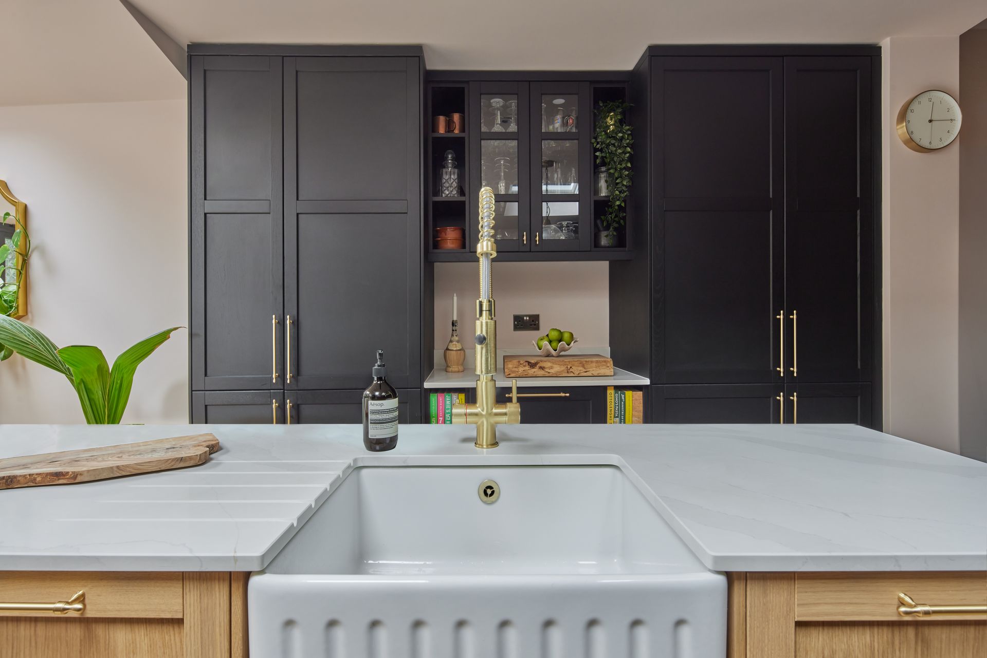 A kitchen with black cabinets and a white sink.