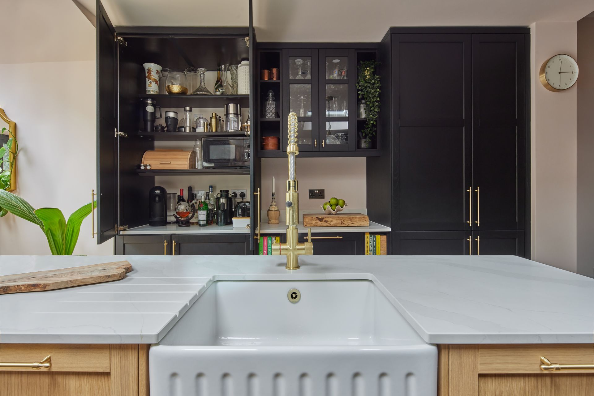A kitchen with a sink and a pantry in the background.