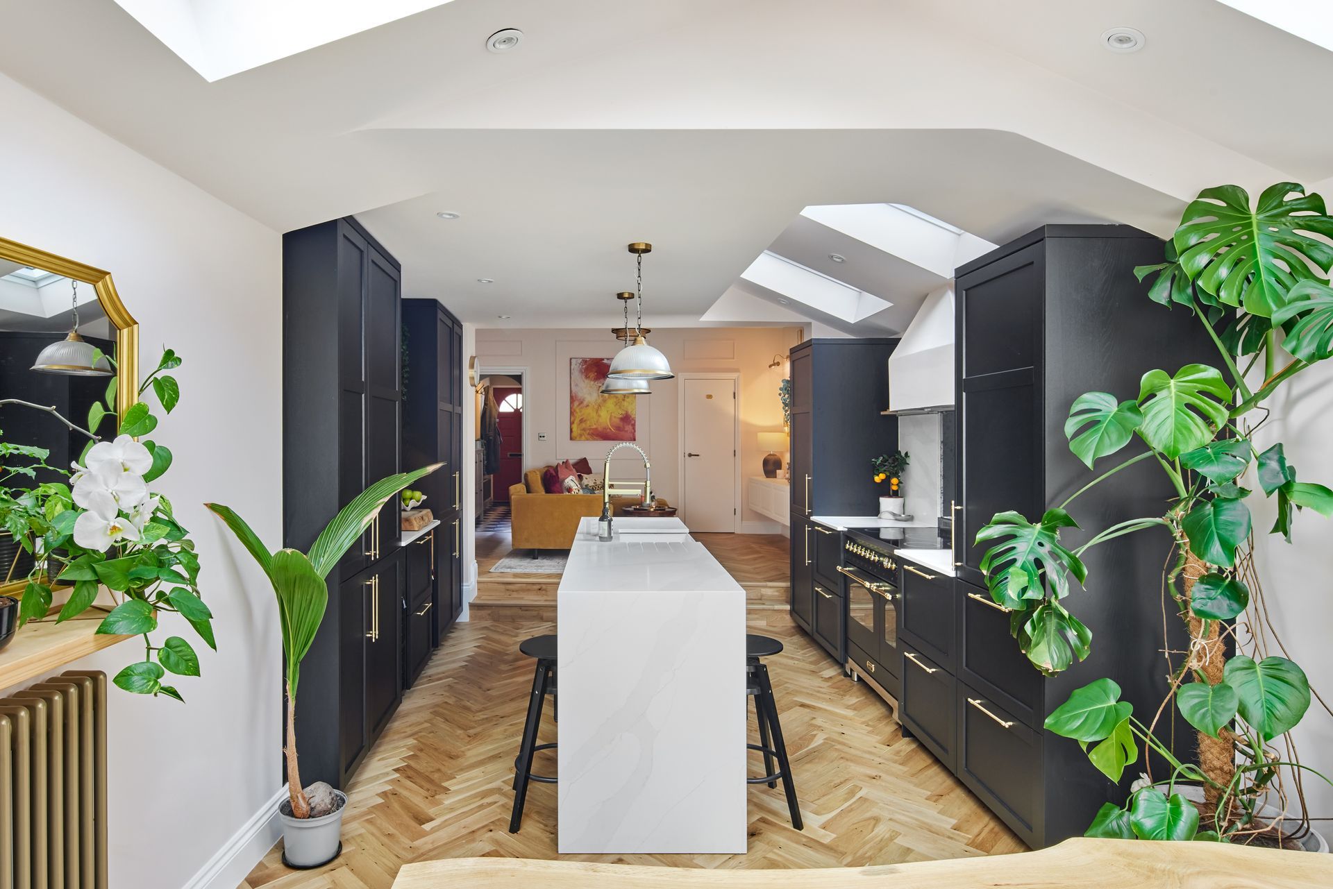 A kitchen with black cabinets and a large island in the middle.