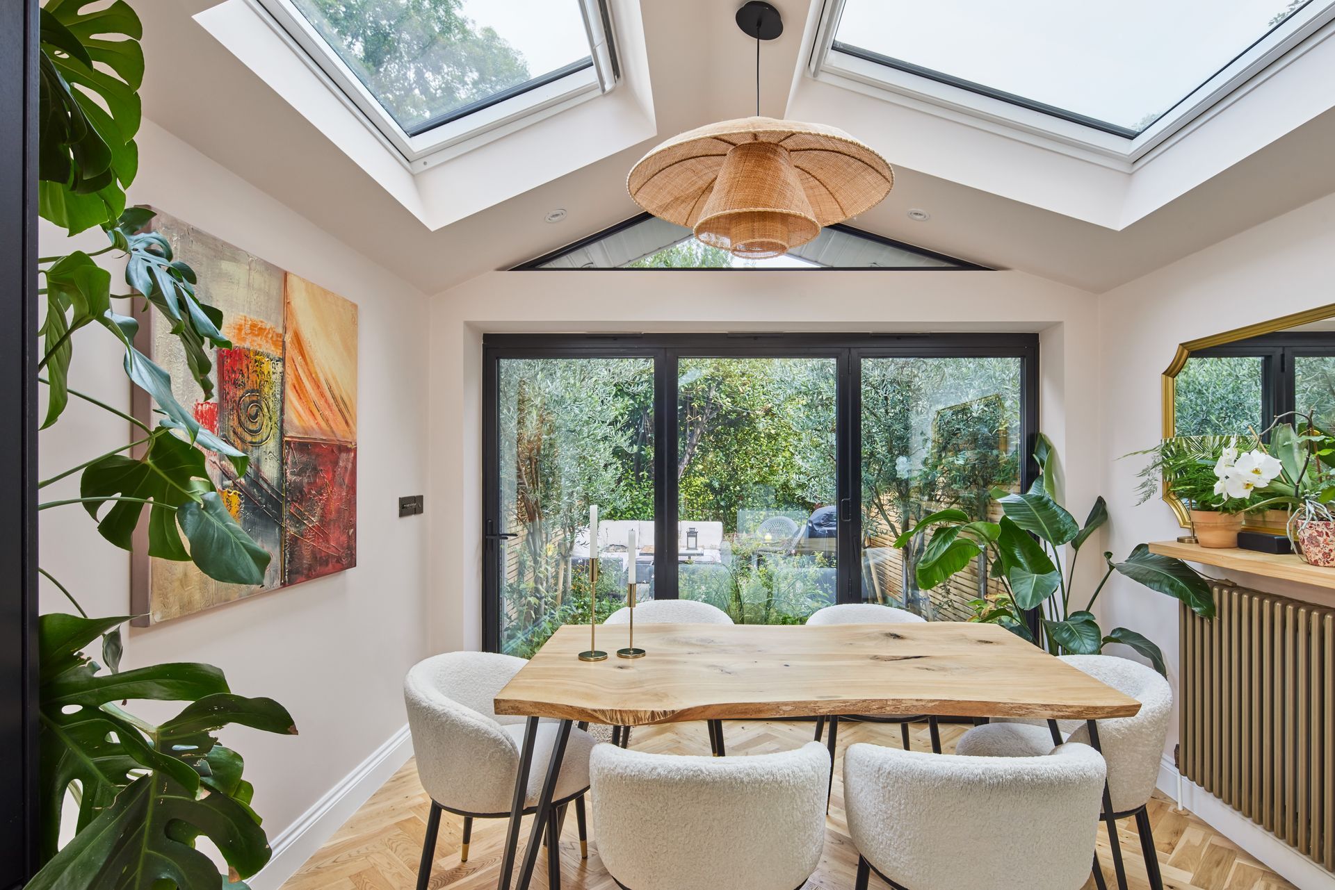 A dining room with a table and chairs and a skylight.