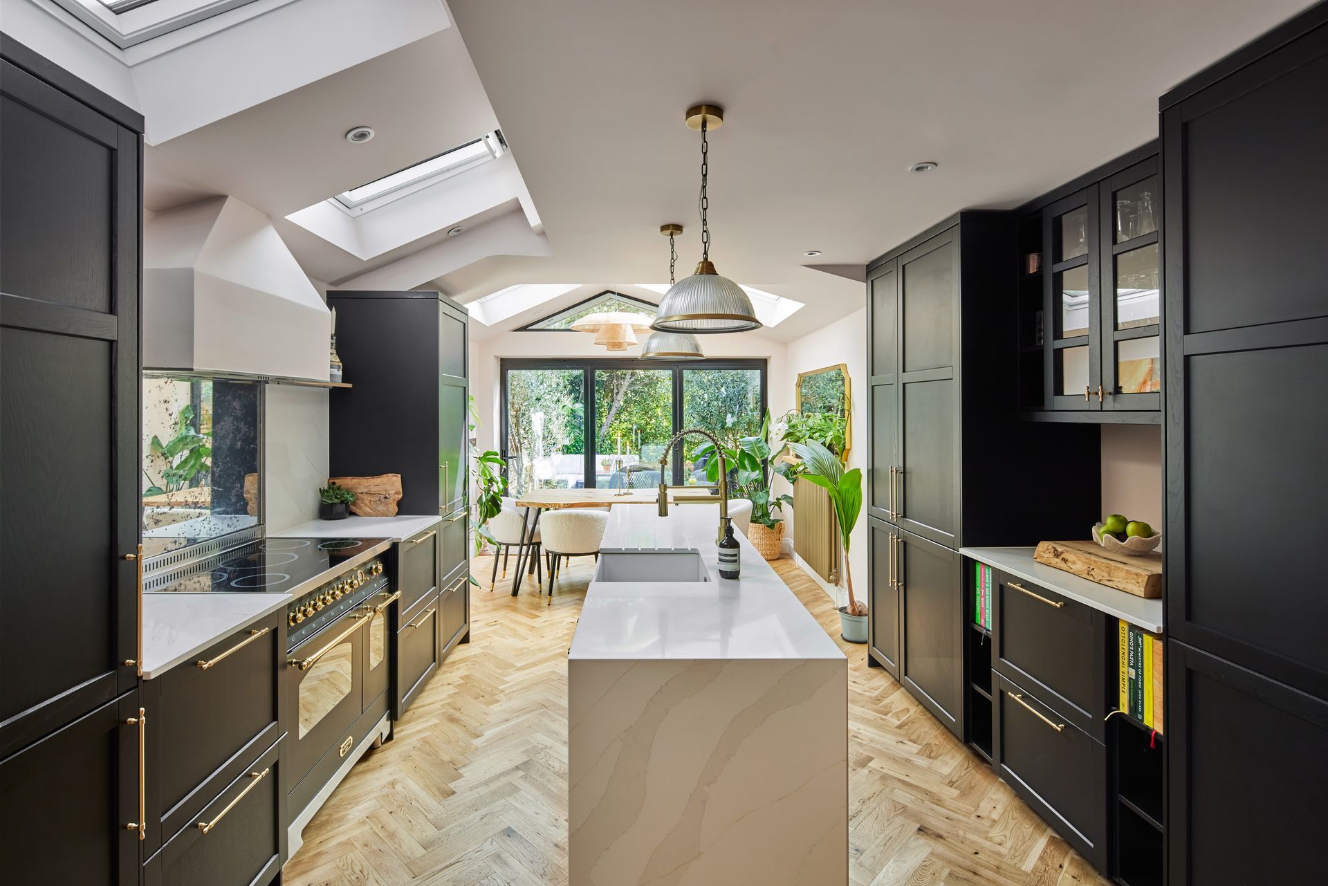 A kitchen with black cabinets and white counter tops and a large island in the middle.