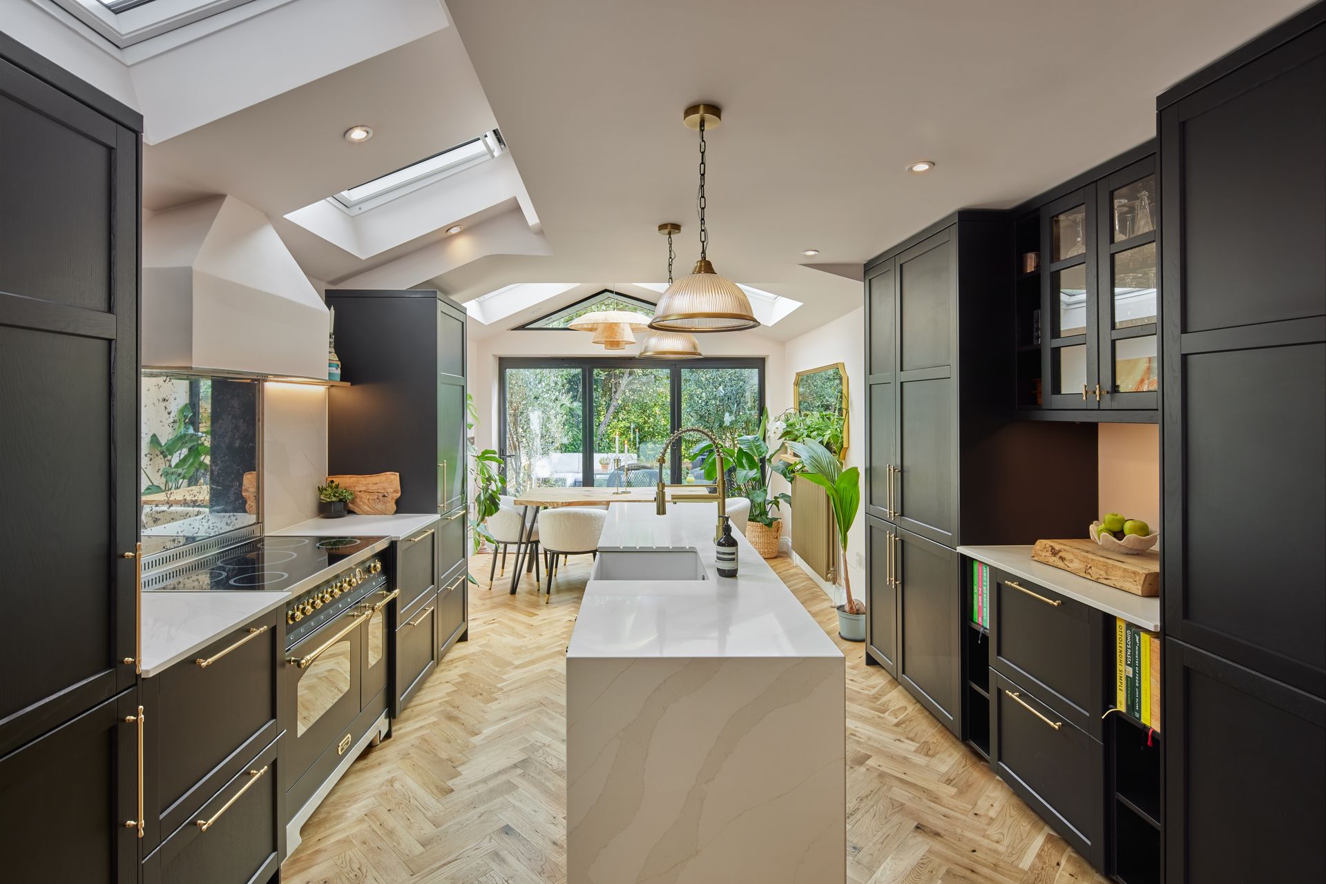 A kitchen with black cabinets and a large island in the middle.