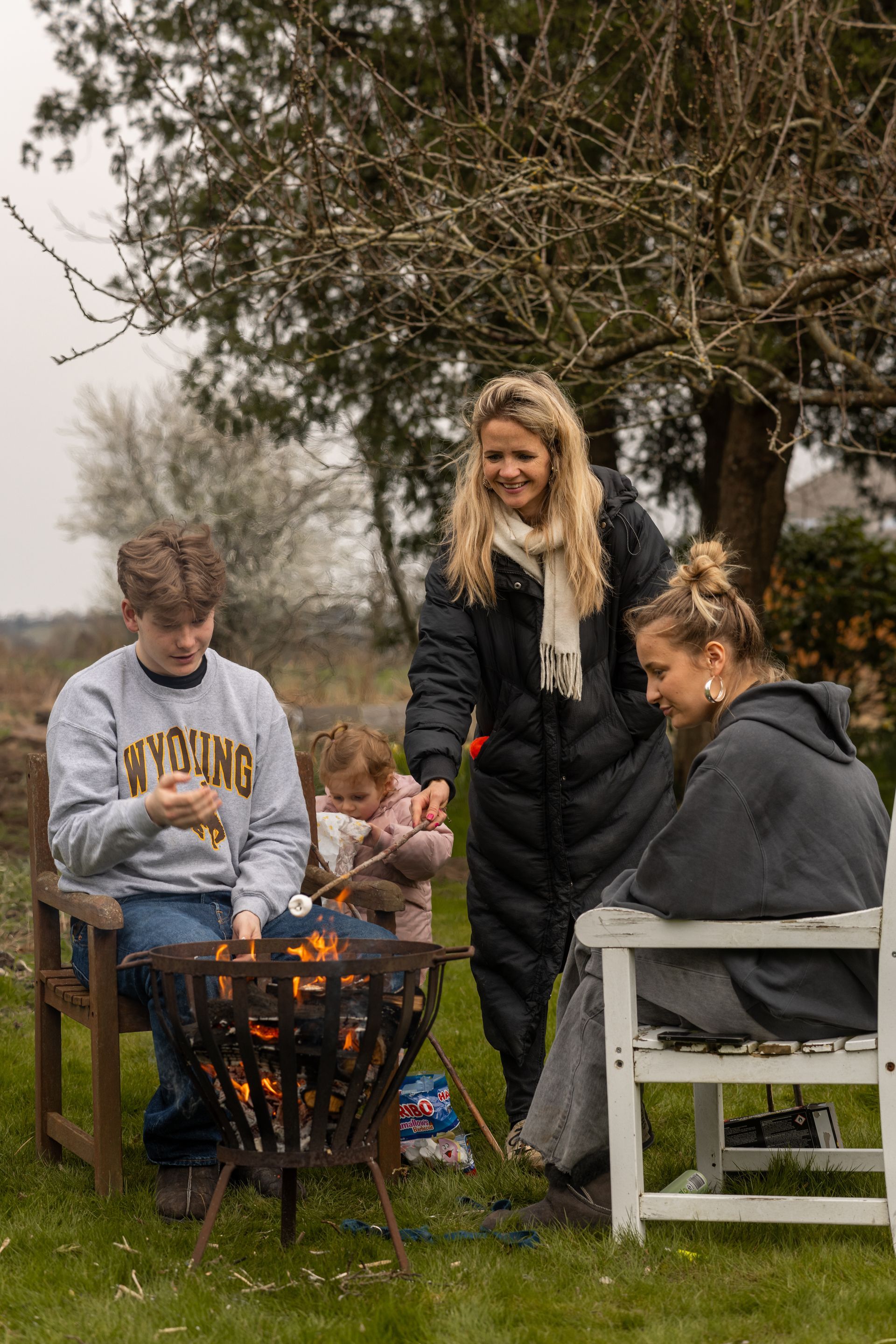 A group of people are sitting around a fire pit.