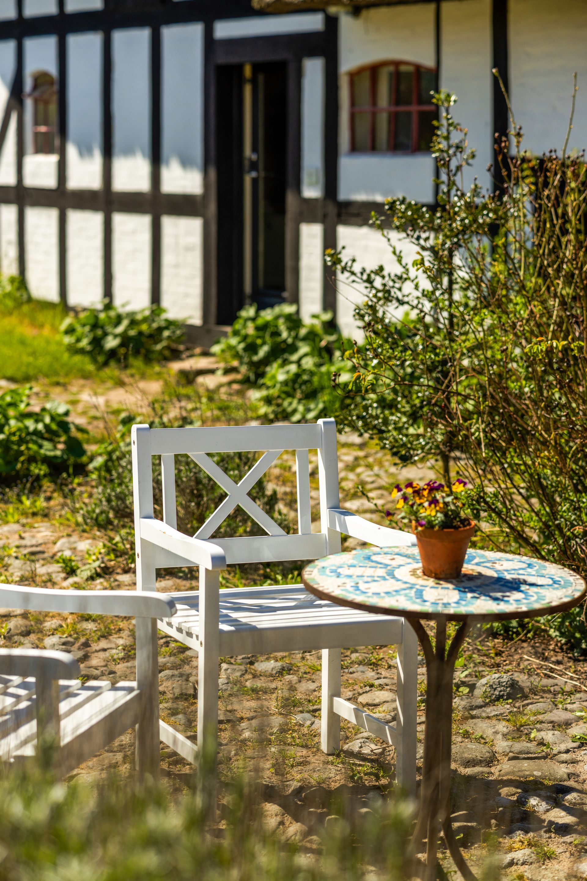 There is a table and chairs in front of a house.