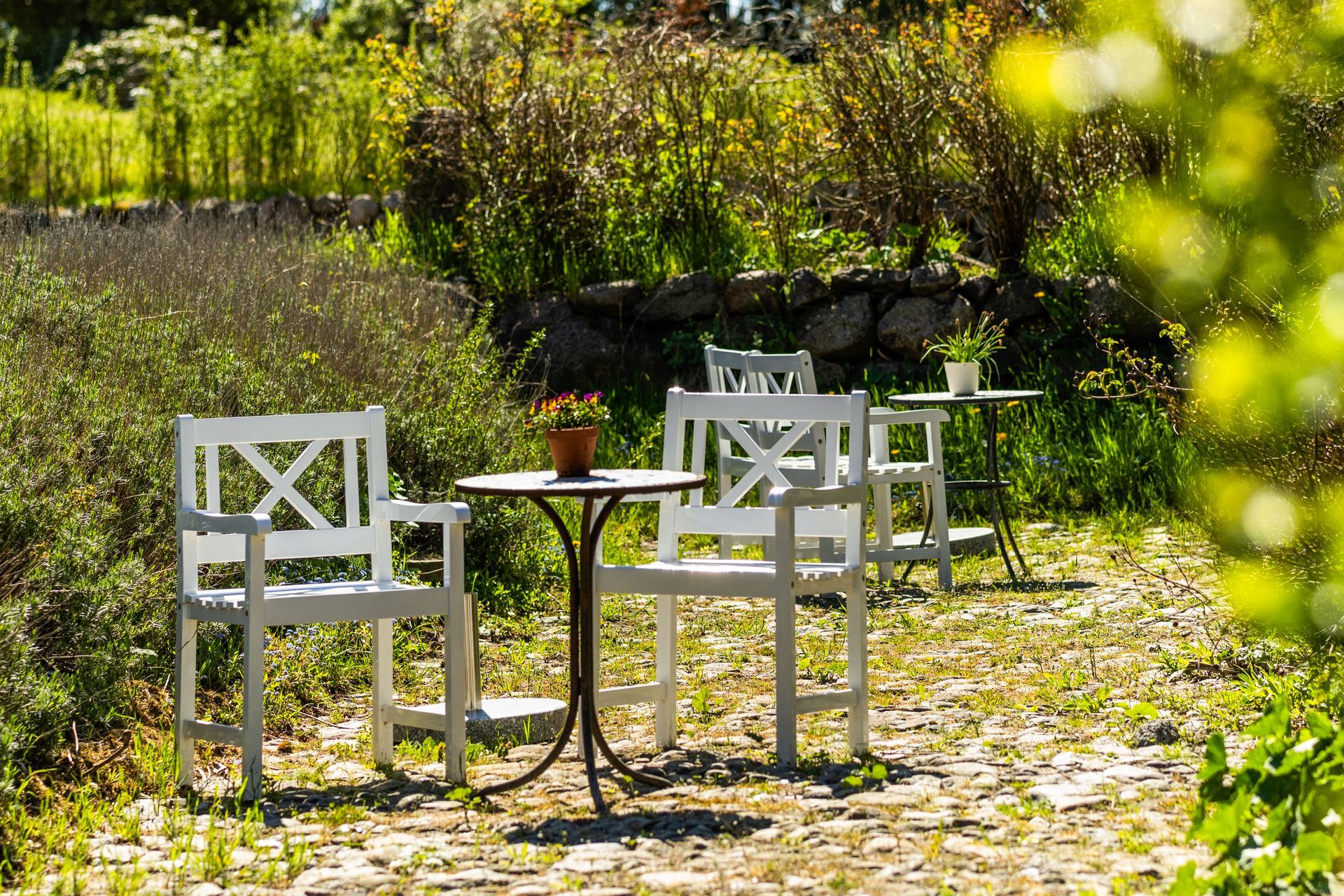 There are two chairs and a table in the garden.