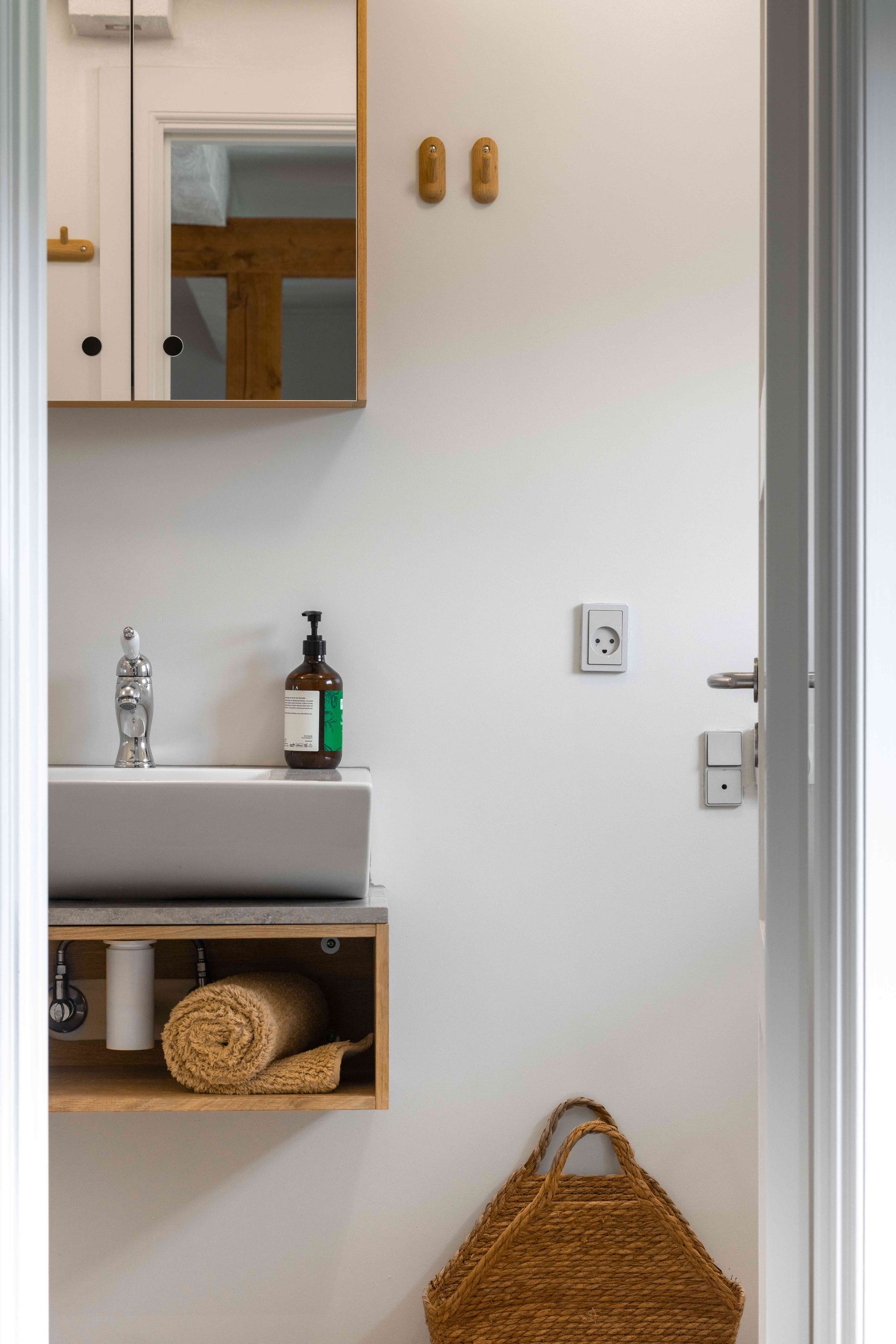 A bathroom with a sink , mirror and towel rack.