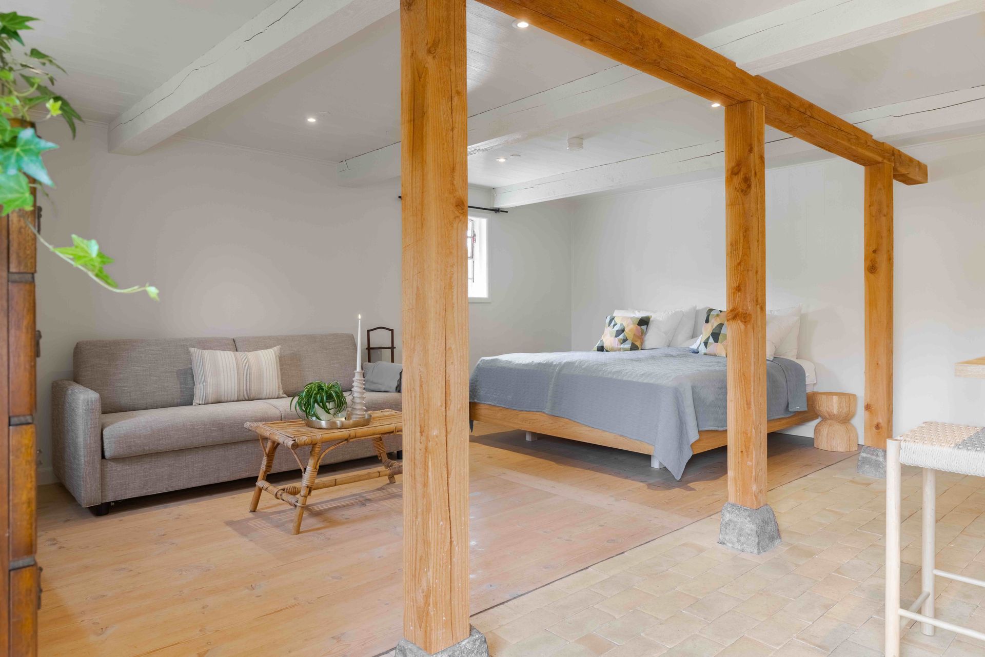 A living room with a couch , table , and two beds.