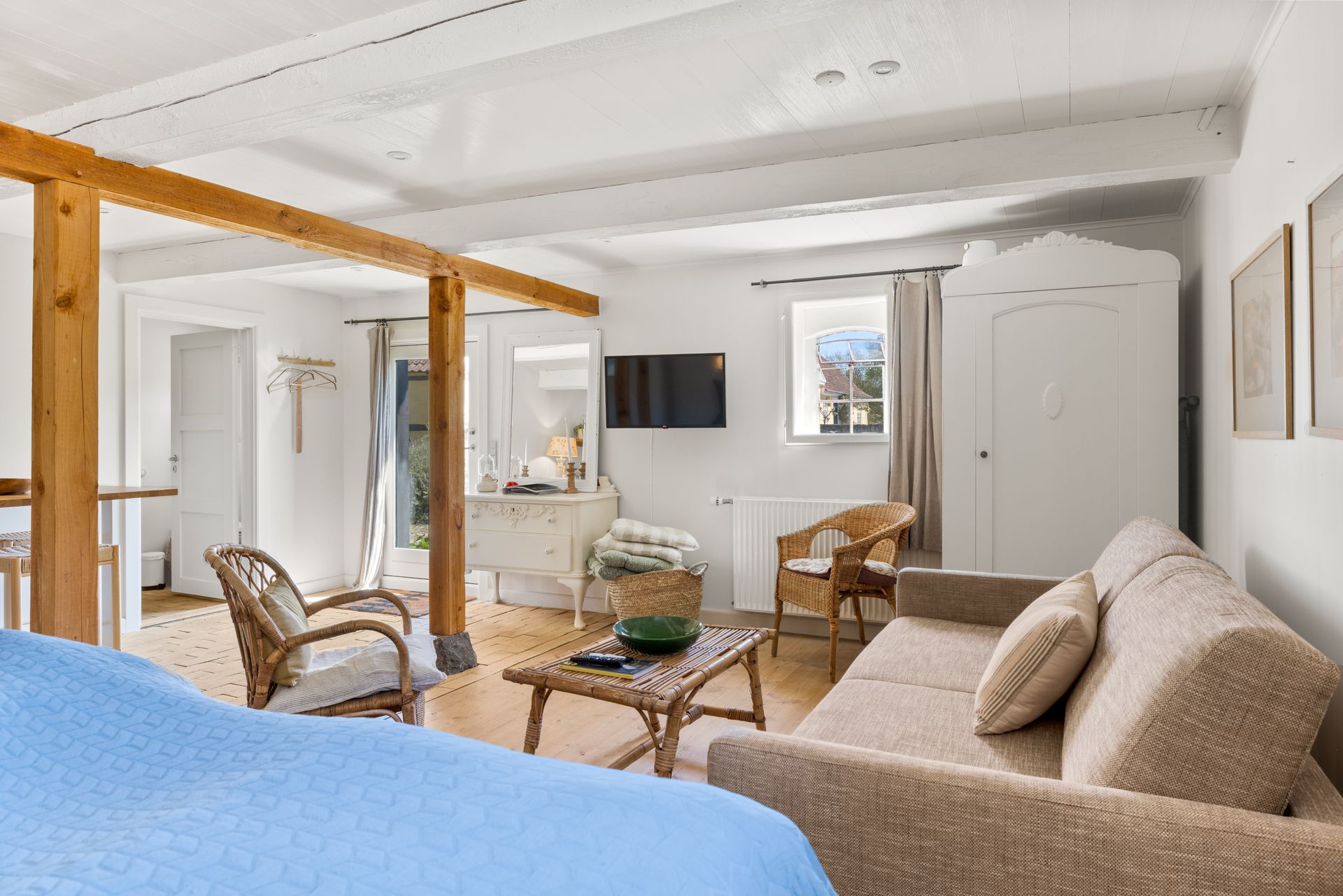 A living room with a couch , chairs , a table and a television.