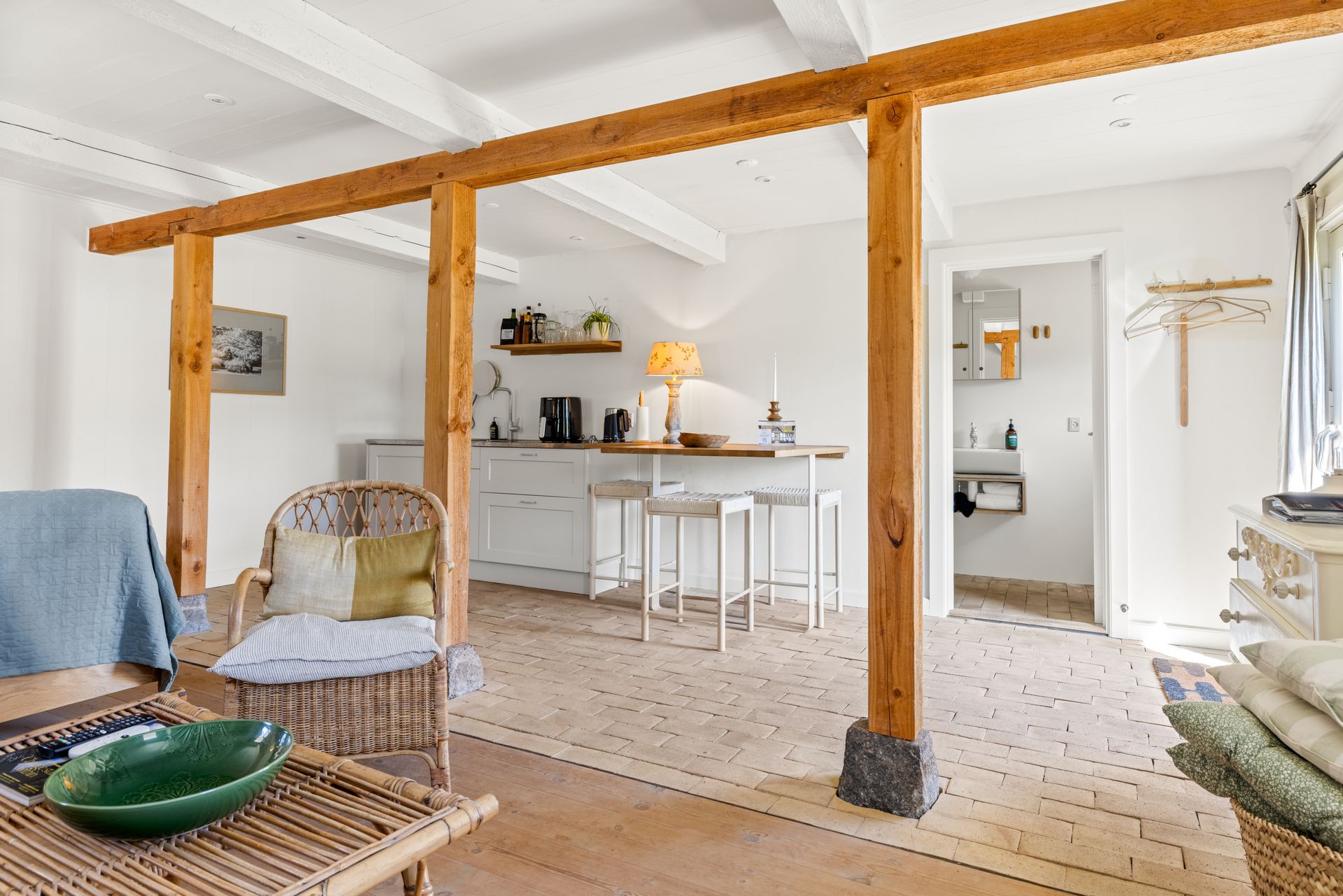 A living room with wooden beams and a wicker chair