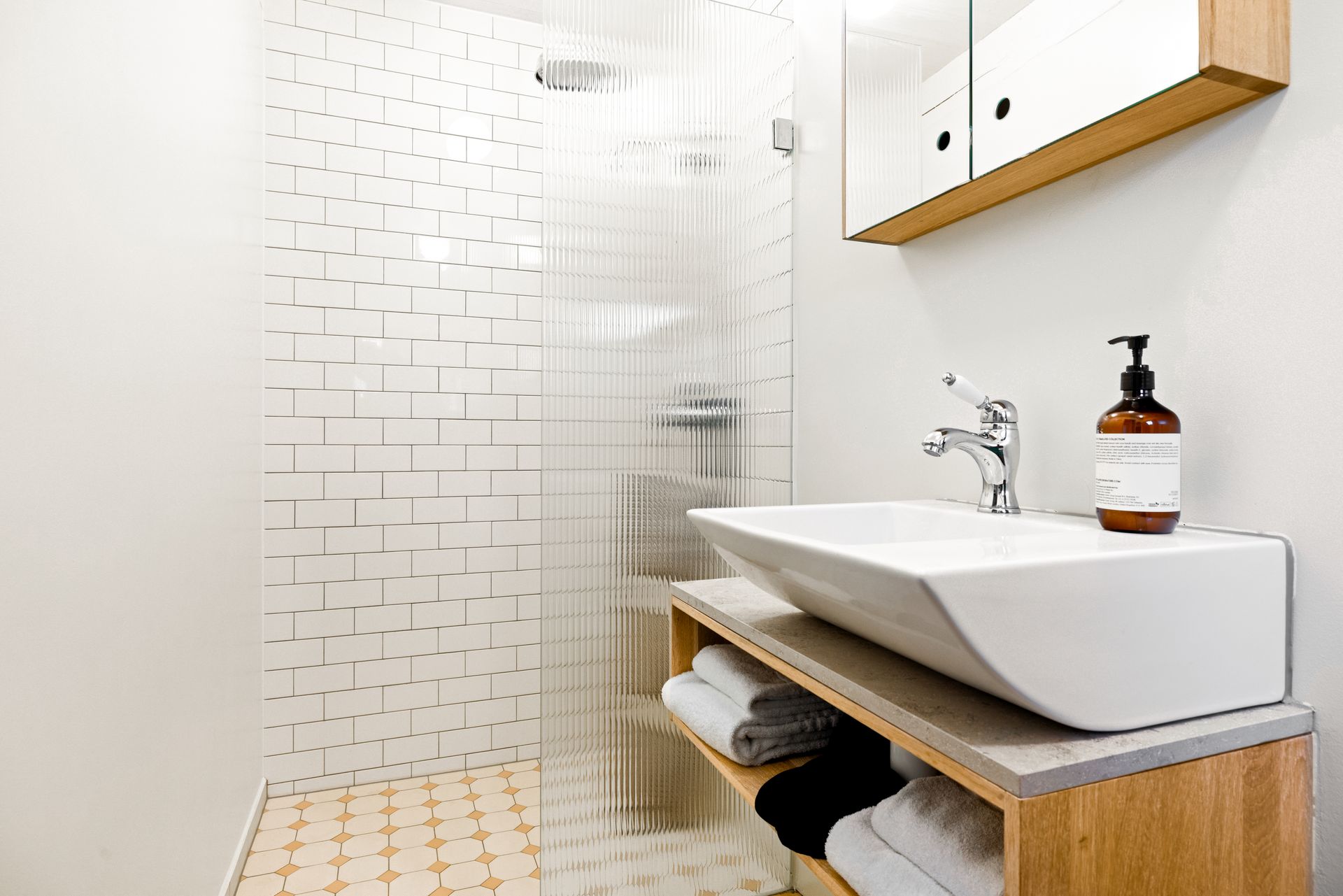 A bathroom with two sinks and a walk in shower.