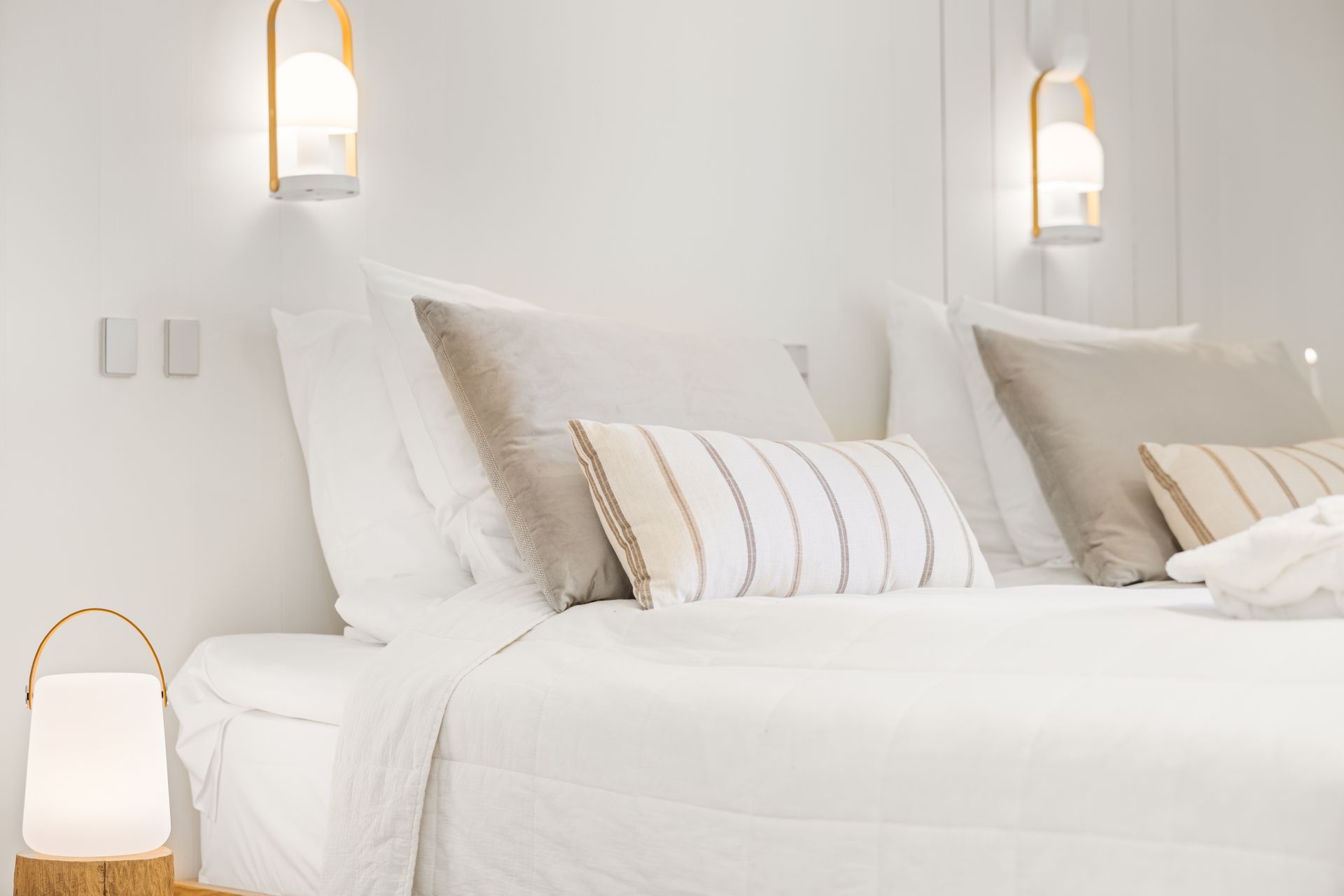 A bedroom with a bed , pillows , and a lamp.