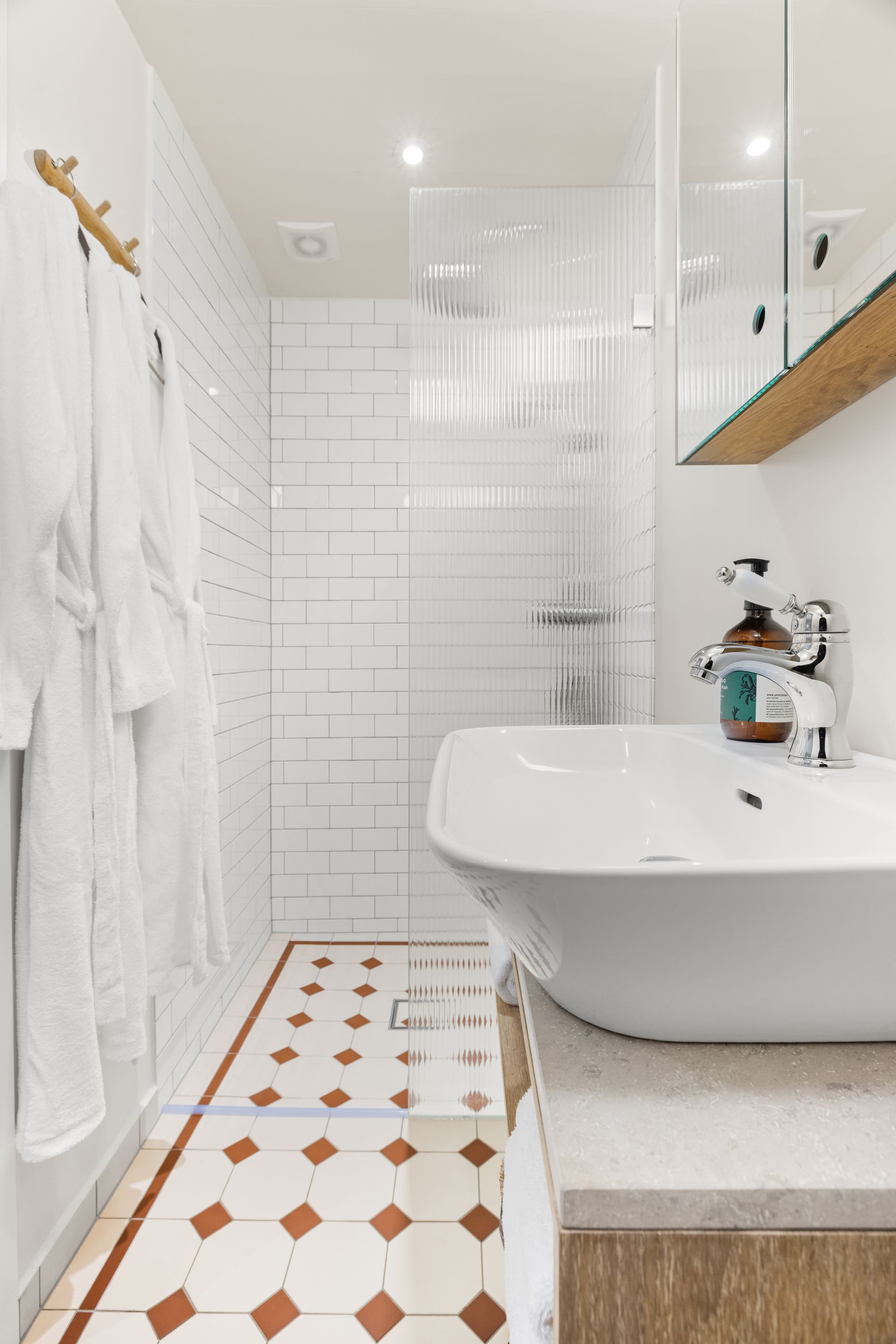A bathroom with a sink and a walk in shower.