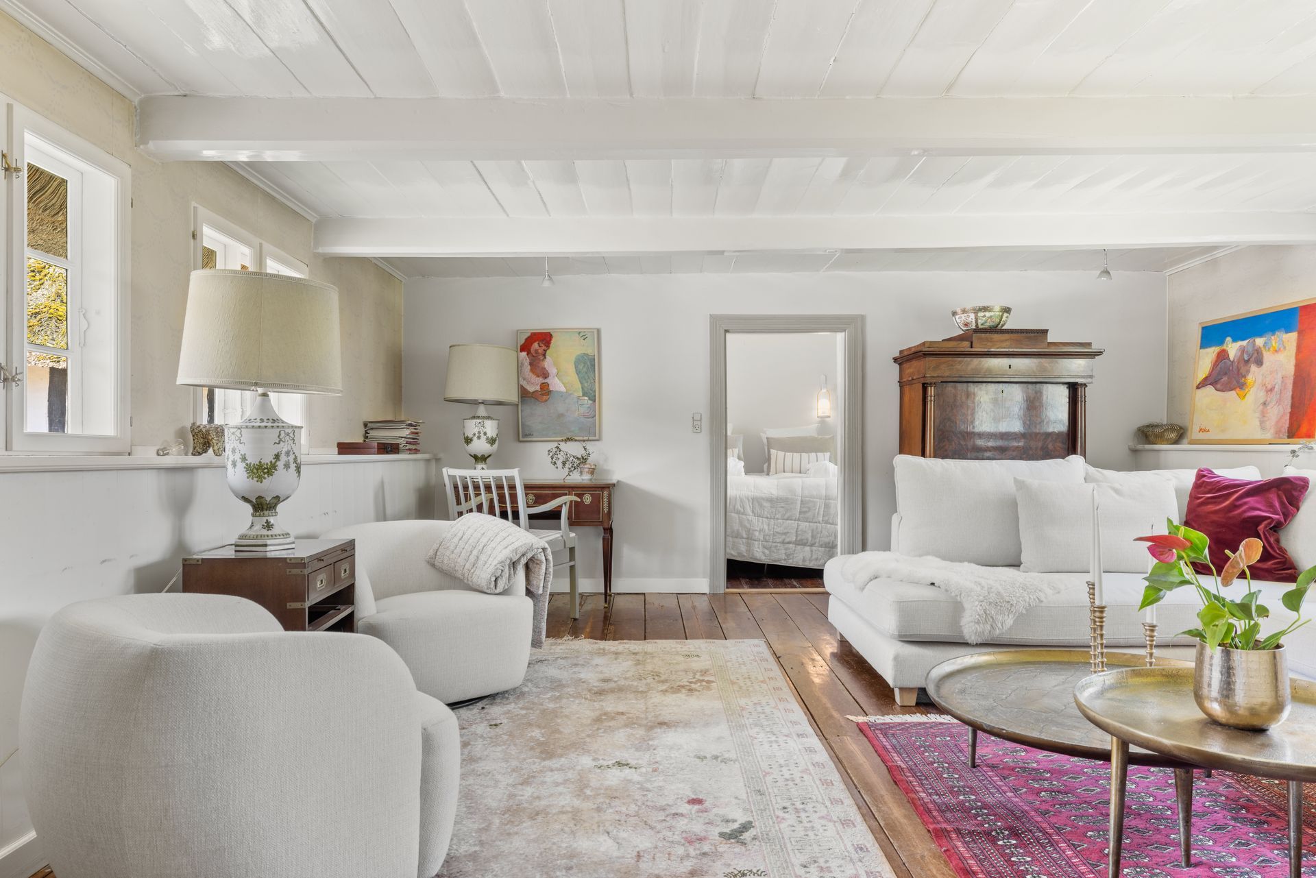 A living room with a couch , chair , coffee table and rug.