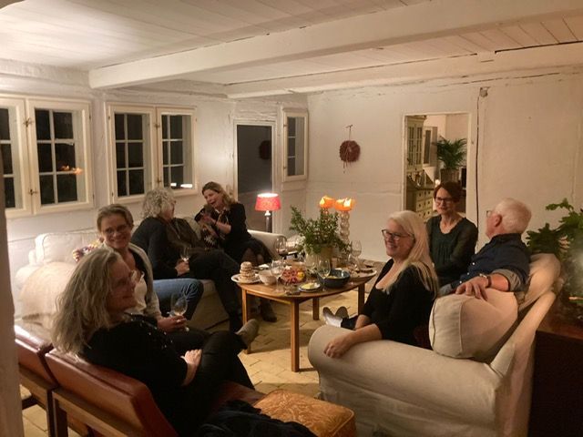 A group of people are sitting around a table in a living room.