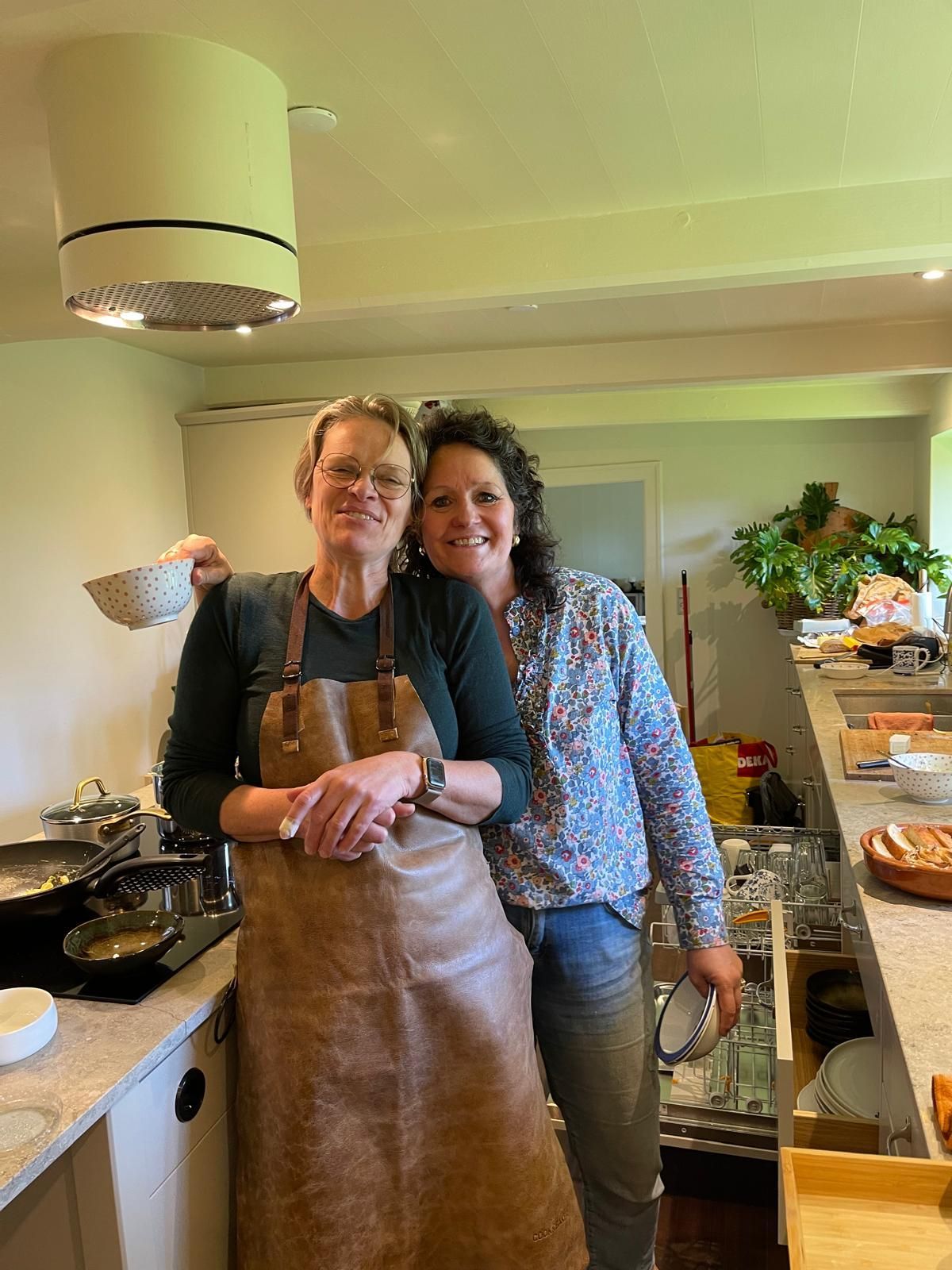 Two women are standing next to each other in a kitchen.