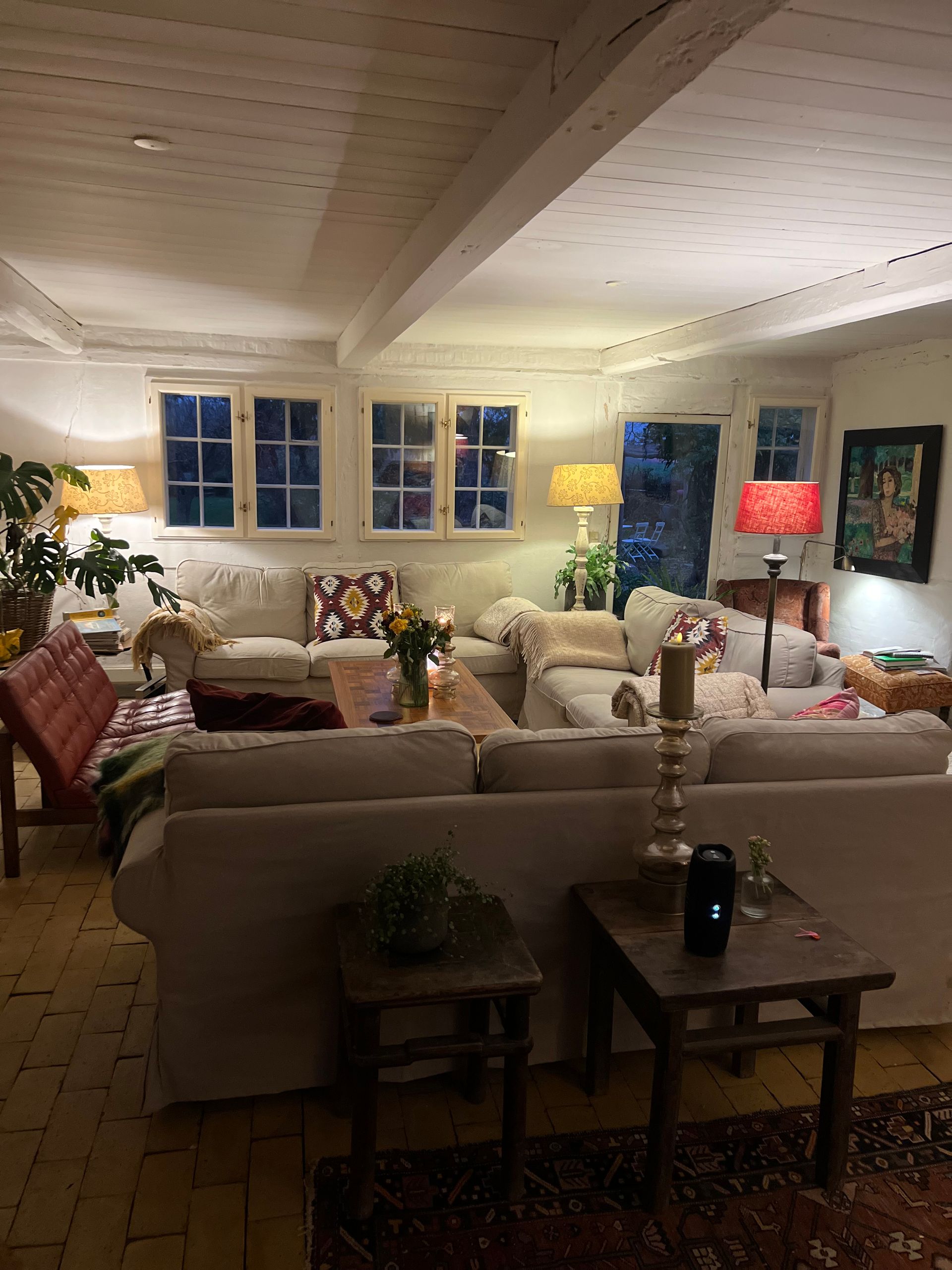 A living room filled with furniture and lamps at night.