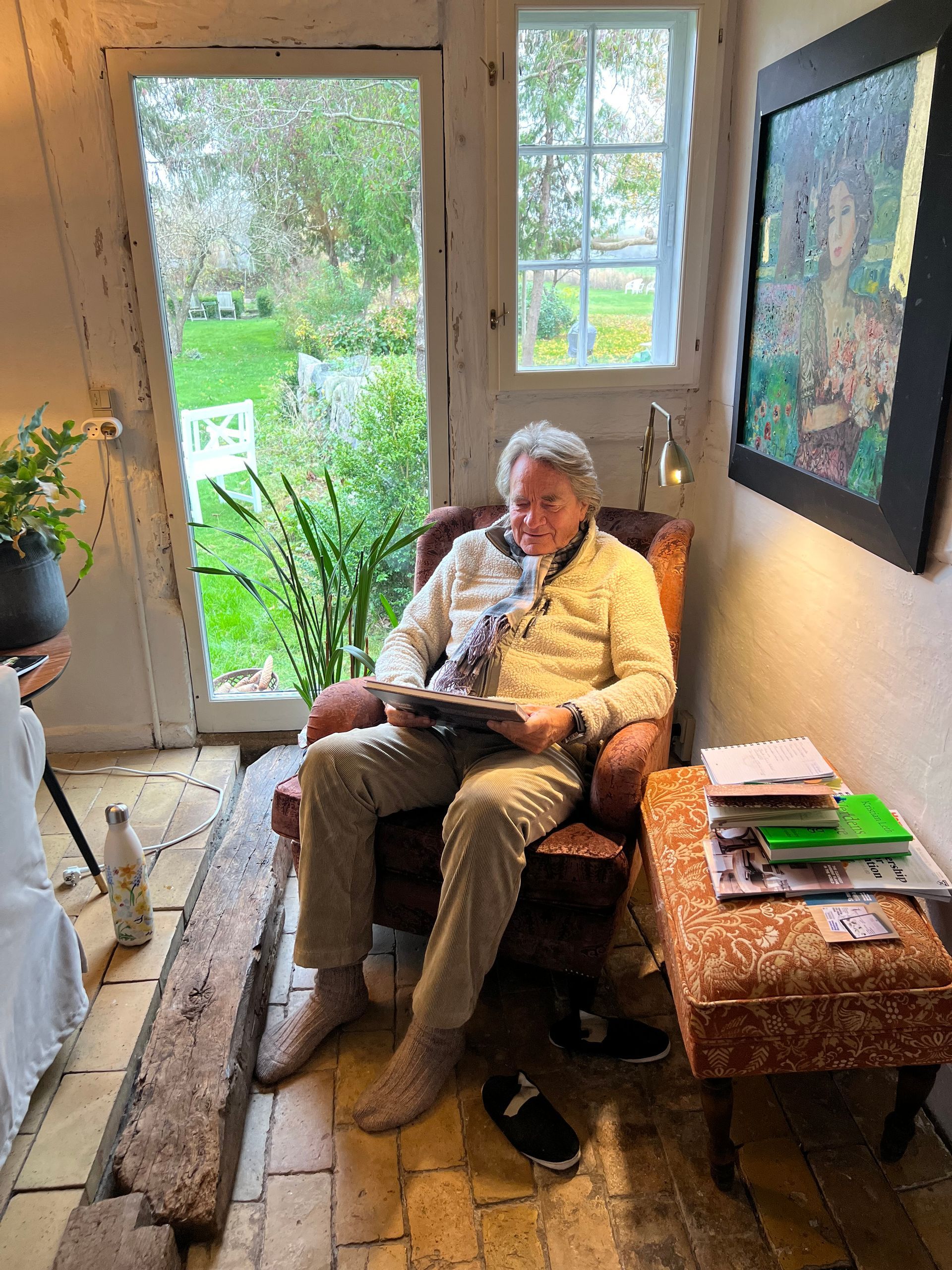 A man is sitting in a chair reading a book.