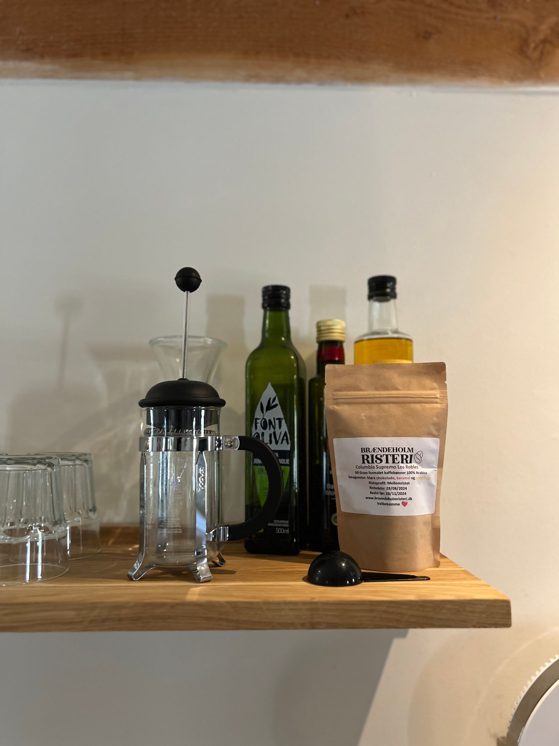 A wooden shelf with bottles and glasses on it