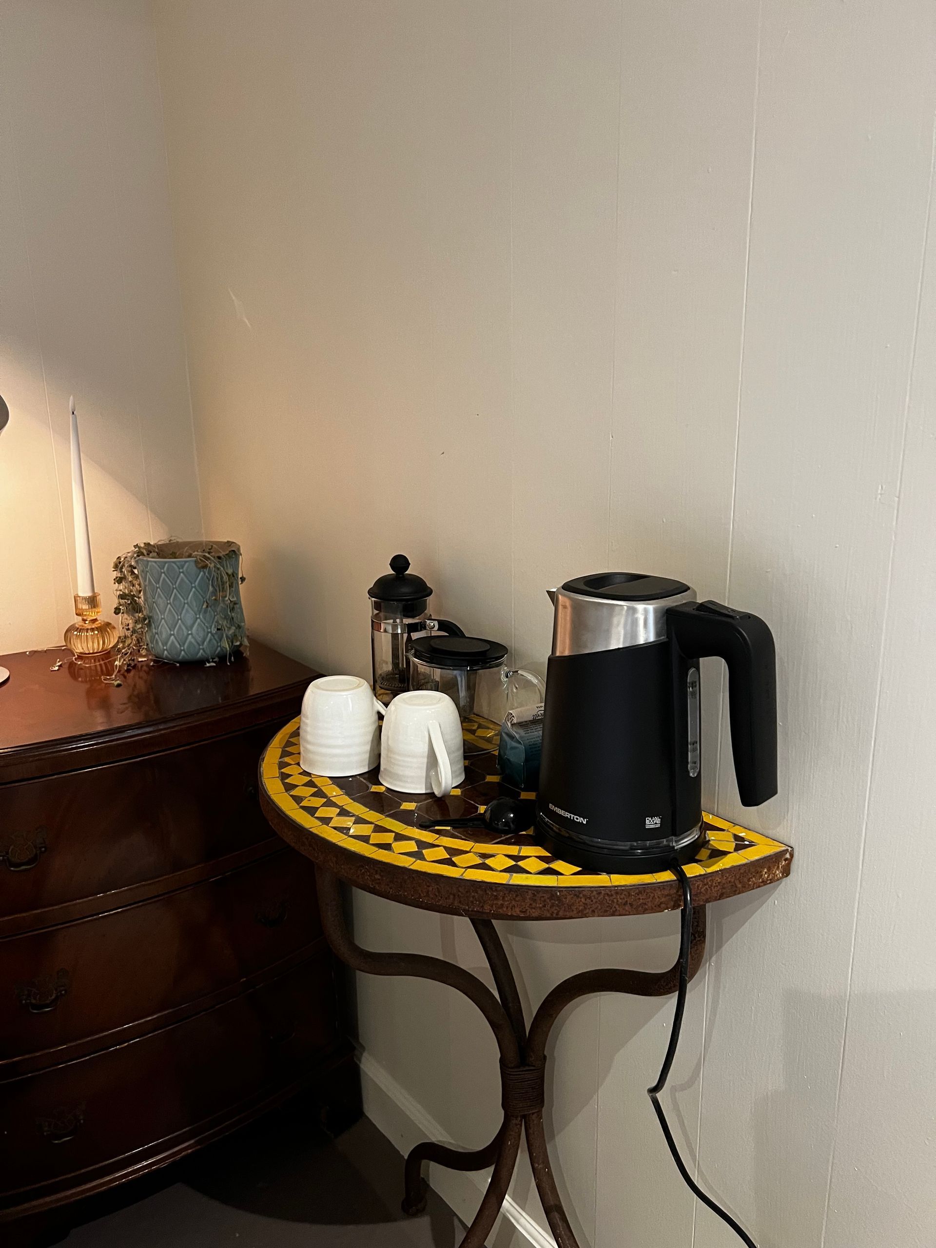 A small table with a kettle and cups on it