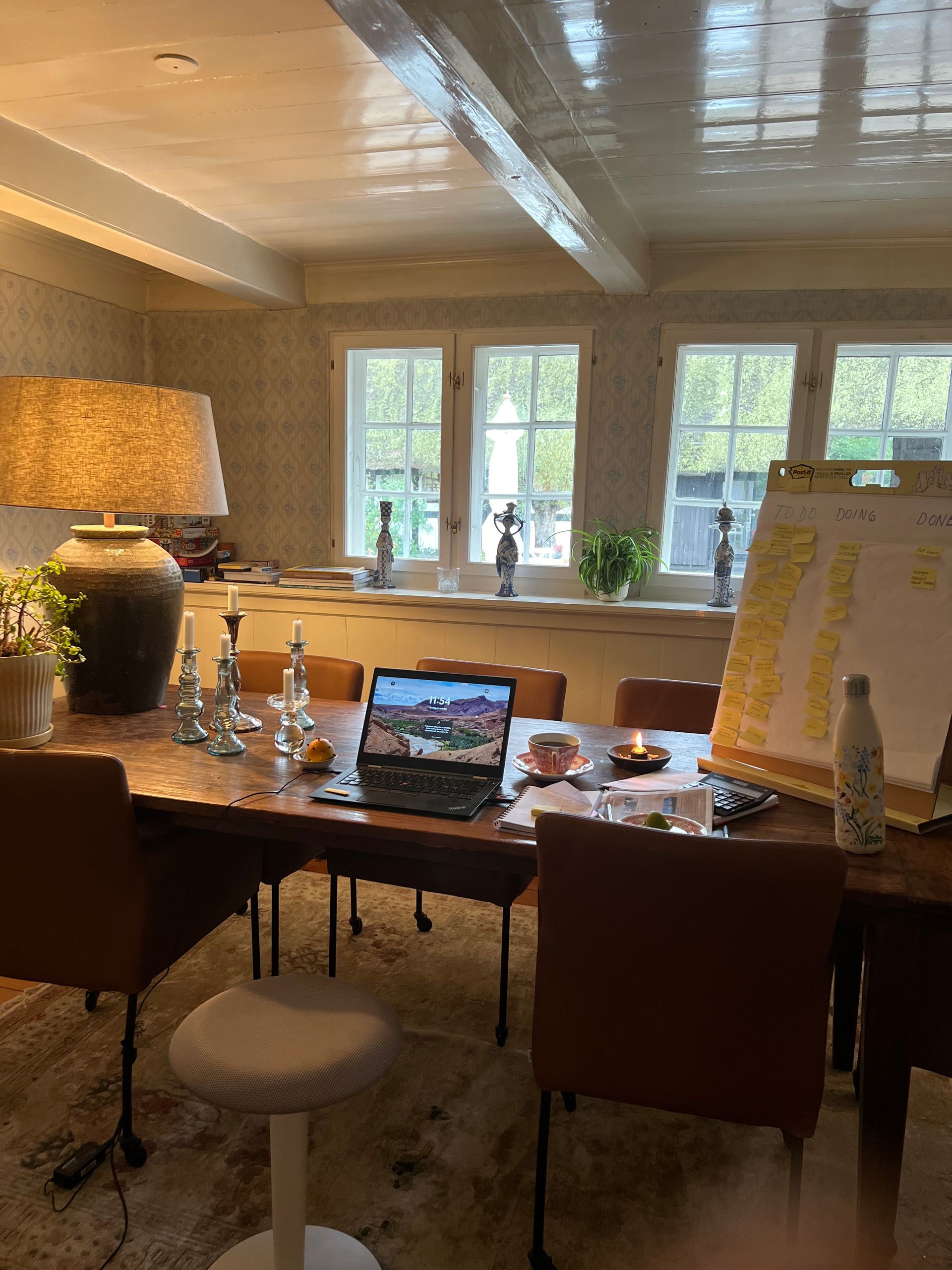 A room with a table and chairs and a laptop on it.