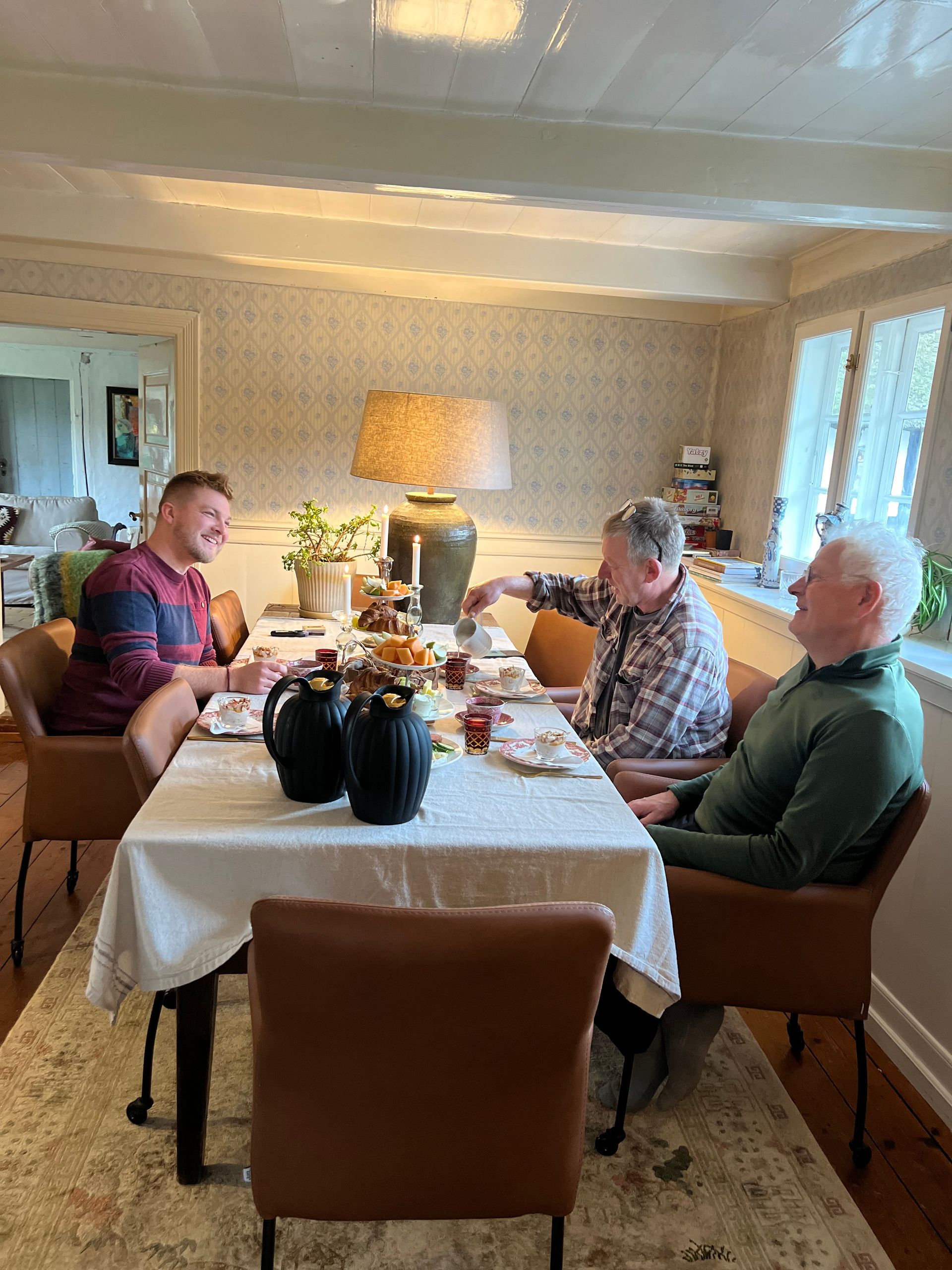 A group of men are sitting at a table in a dining room.