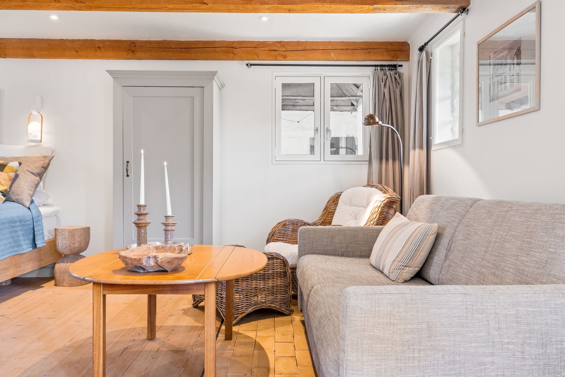 A living room with a couch , chair , table and candles.