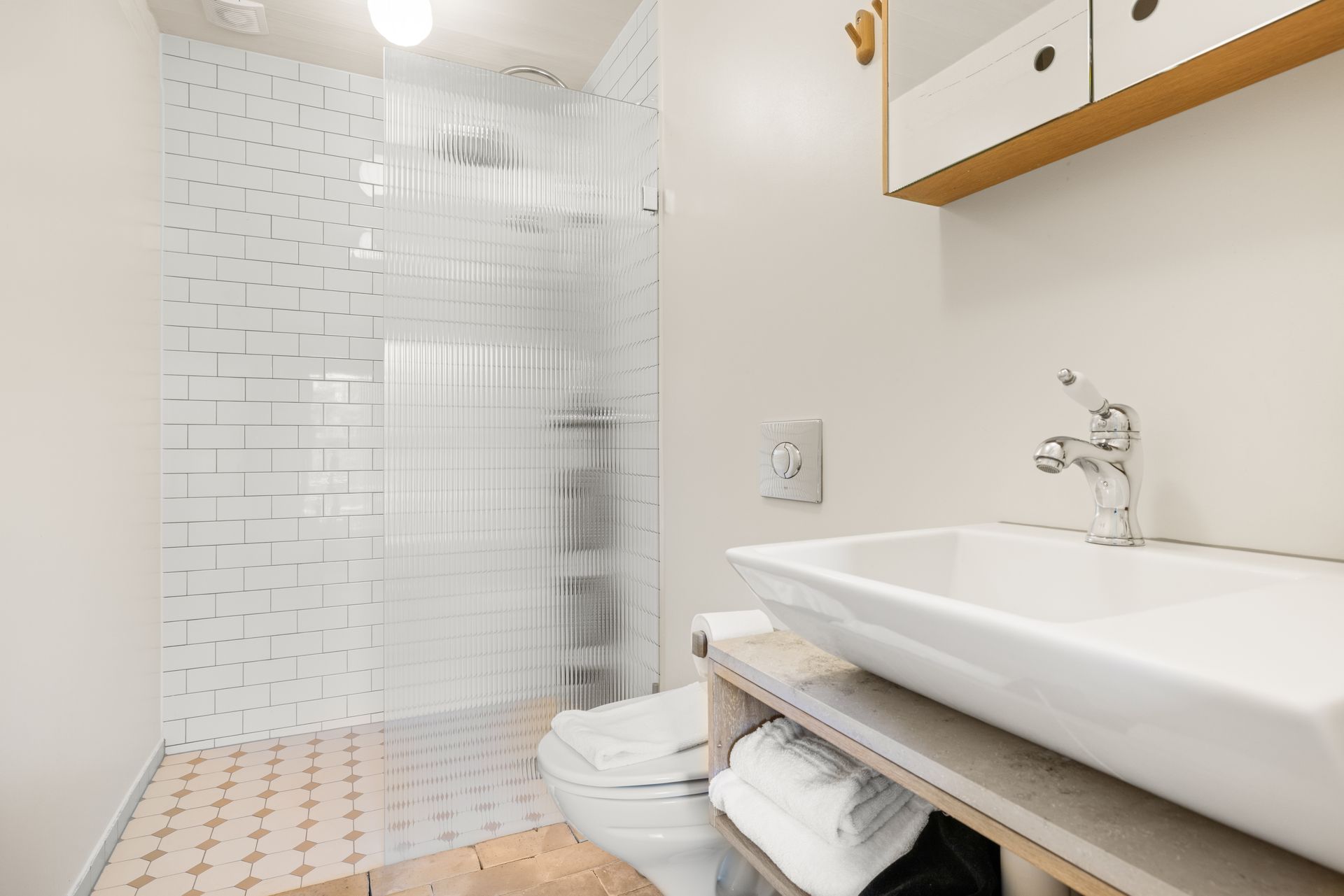 A bathroom with a sink , toilet and walk in shower.