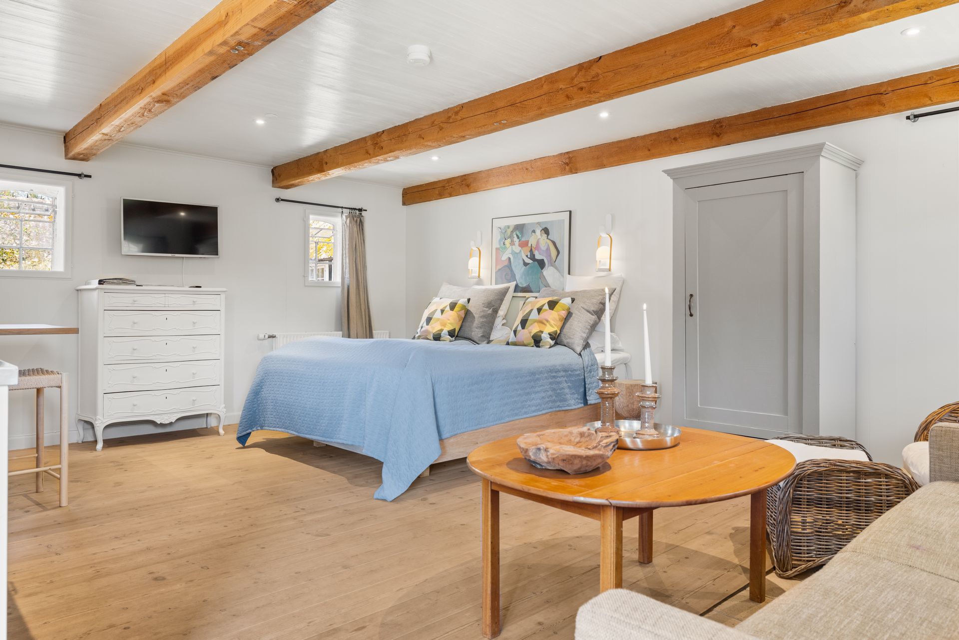 A bedroom with a bed , couch , table and television.