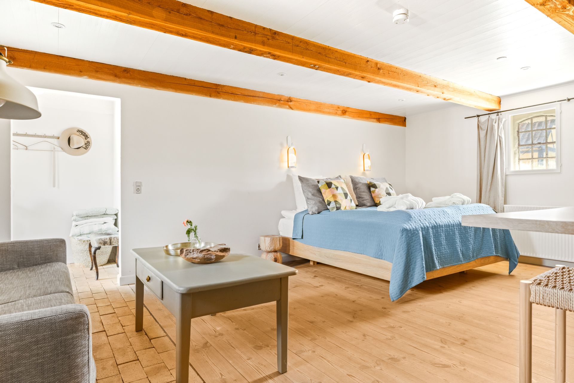 A bedroom with two beds , a coffee table and a couch.