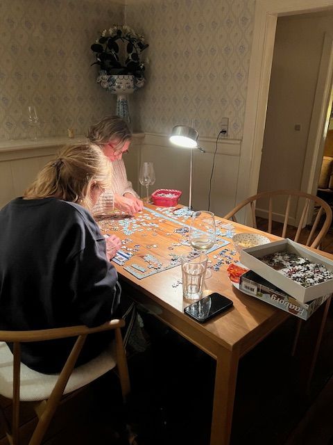 Two people are sitting at a table playing a game of puzzles.