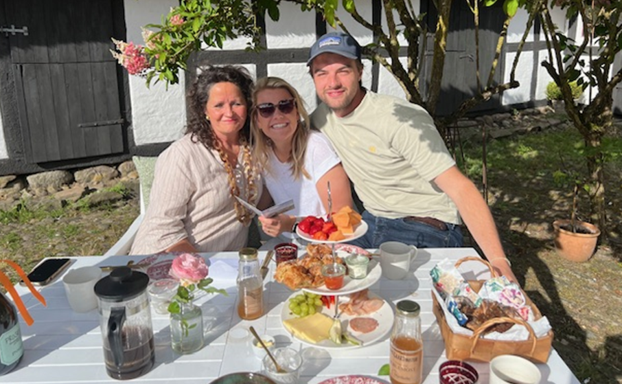 A group of people are sitting at a table with food on it.