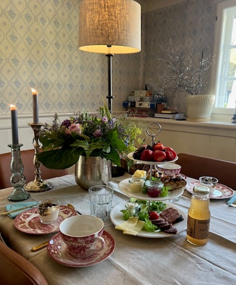A table with plates of food and candles on it