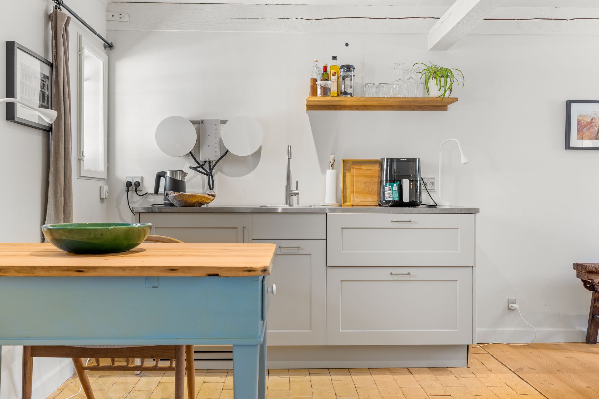 A kitchen with a table and chairs and a sink.